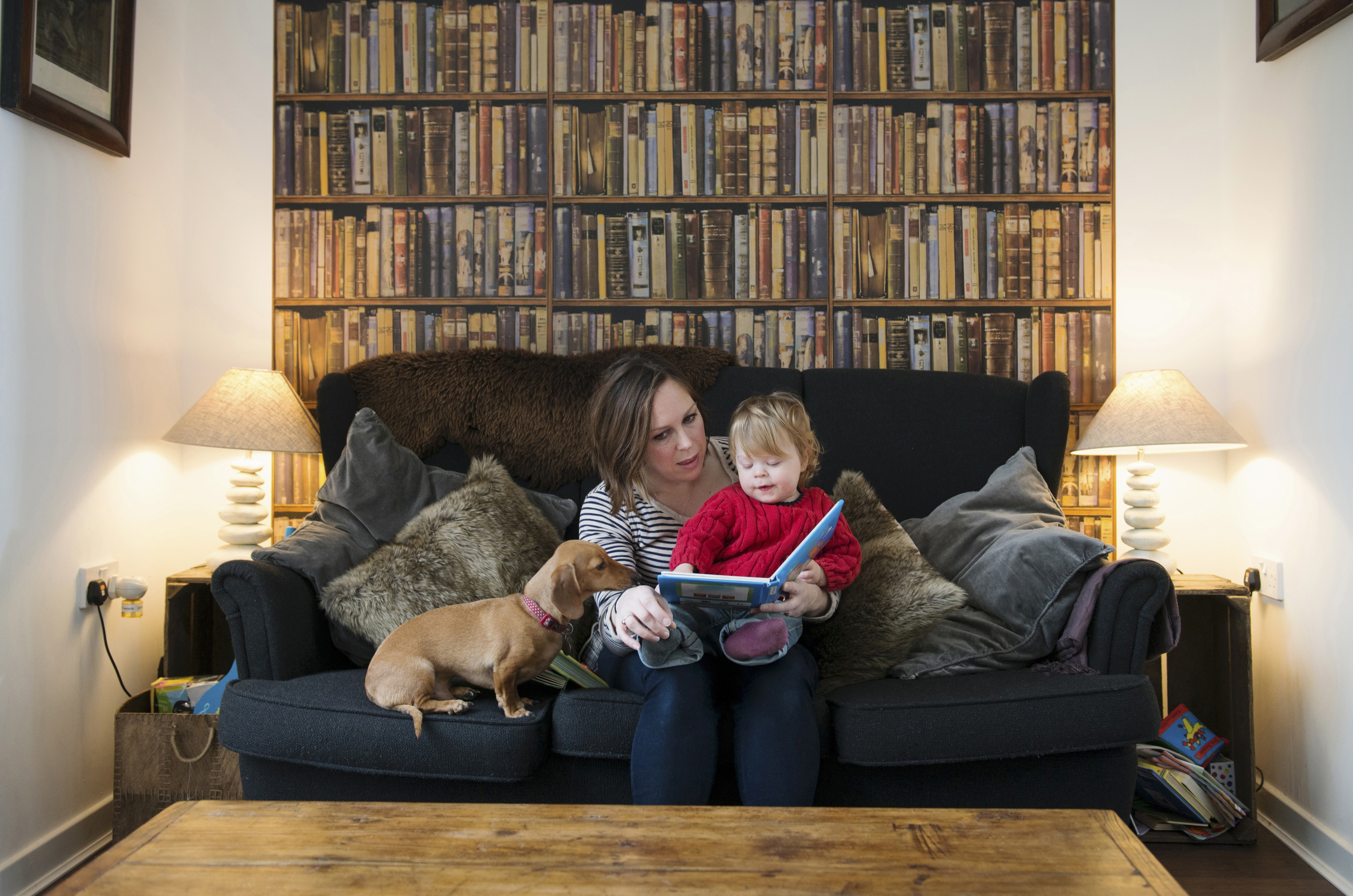 12 Feb 2015 --- Mother reading book to son on sofa --- Image by © Corbis [26JANUARY2016 FEATURES FAMILY]