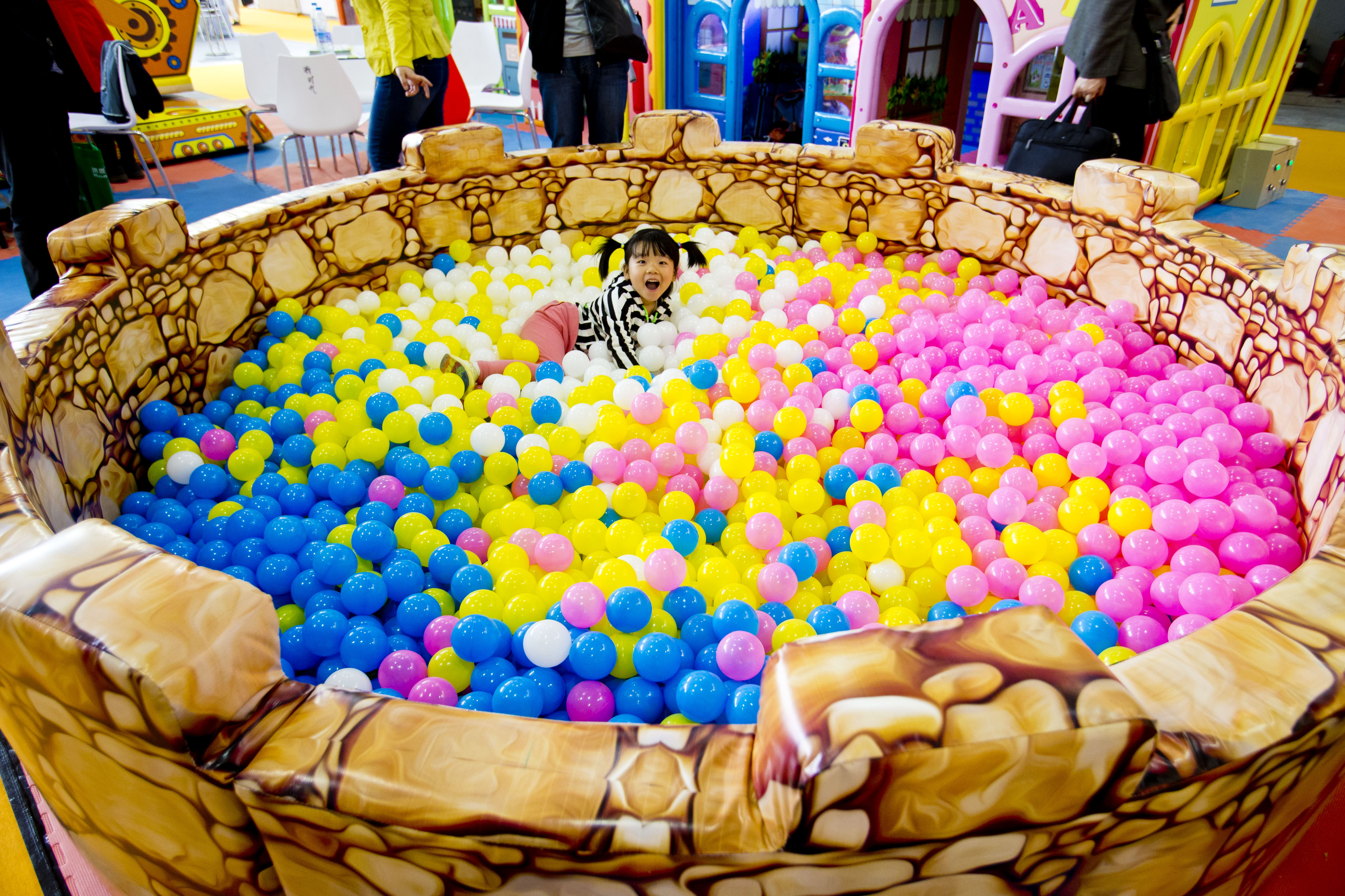 (140425) -- BEIJING, April 25, 2014 (Xinhua) -- A girl plays in colorful plastic pit balls during the 16th Beijing International Kindergarten Supplies & Auxiliary Equipment Exhibition, in Beijing, capital of China, April 24, 2014. Some 200 enterprises from more than 20 countries and regions took part in the exhibition, which kicked off here Thursday. (Xinhua/Zhao Bing) (wyo)
