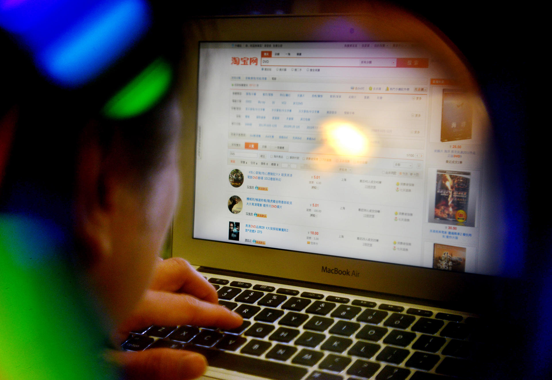 A photo illustration showing a man browsing DVDs for sale on Taobao. 07SEP12