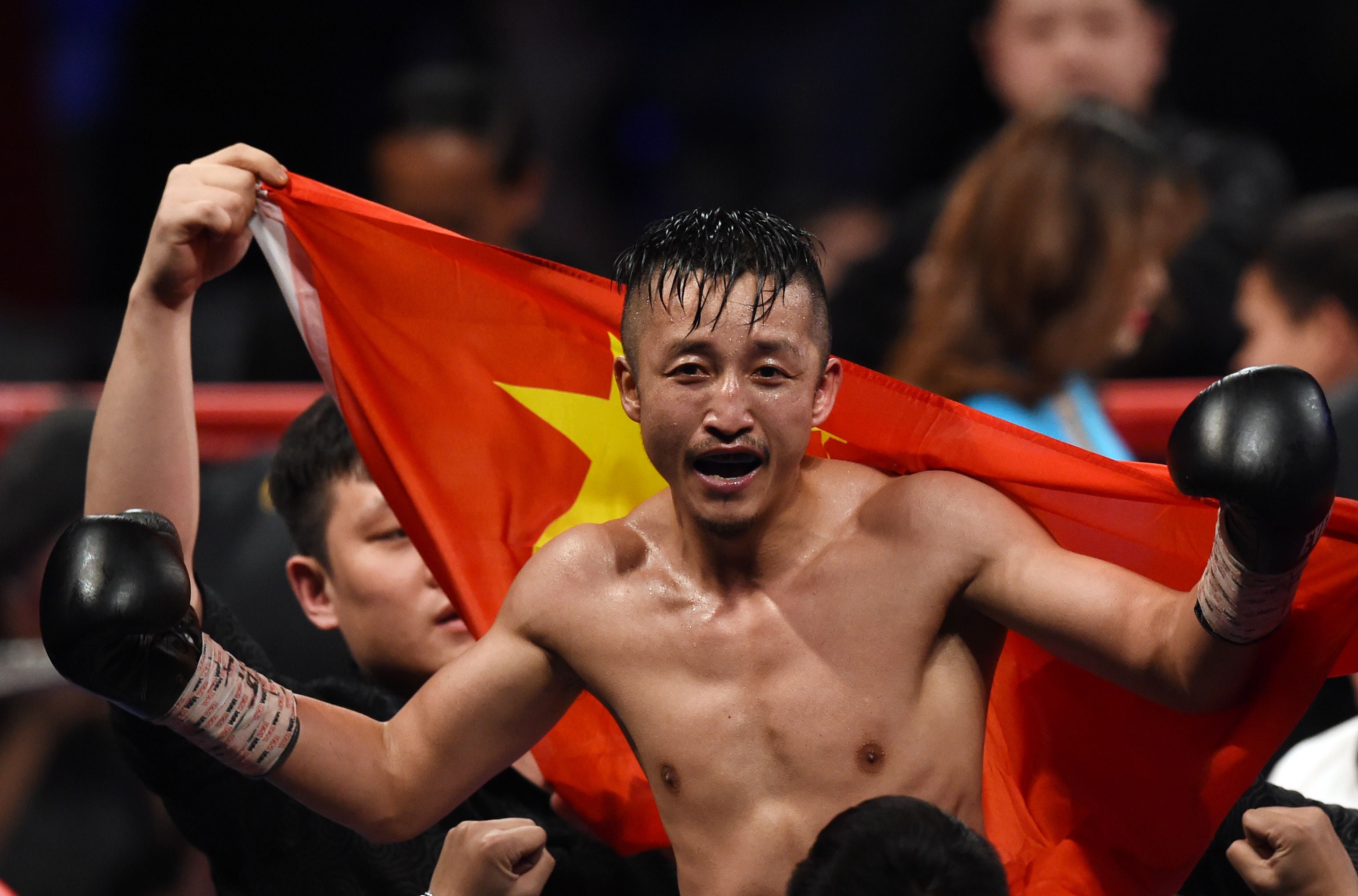 Zou Shiming of China celebrates after winning against Natan Coutinho of Brazil in their WBO international flyweight boxing title bout in Shanghai on January 30, 2016. AFP PHOTO / JOHANNES EISELE