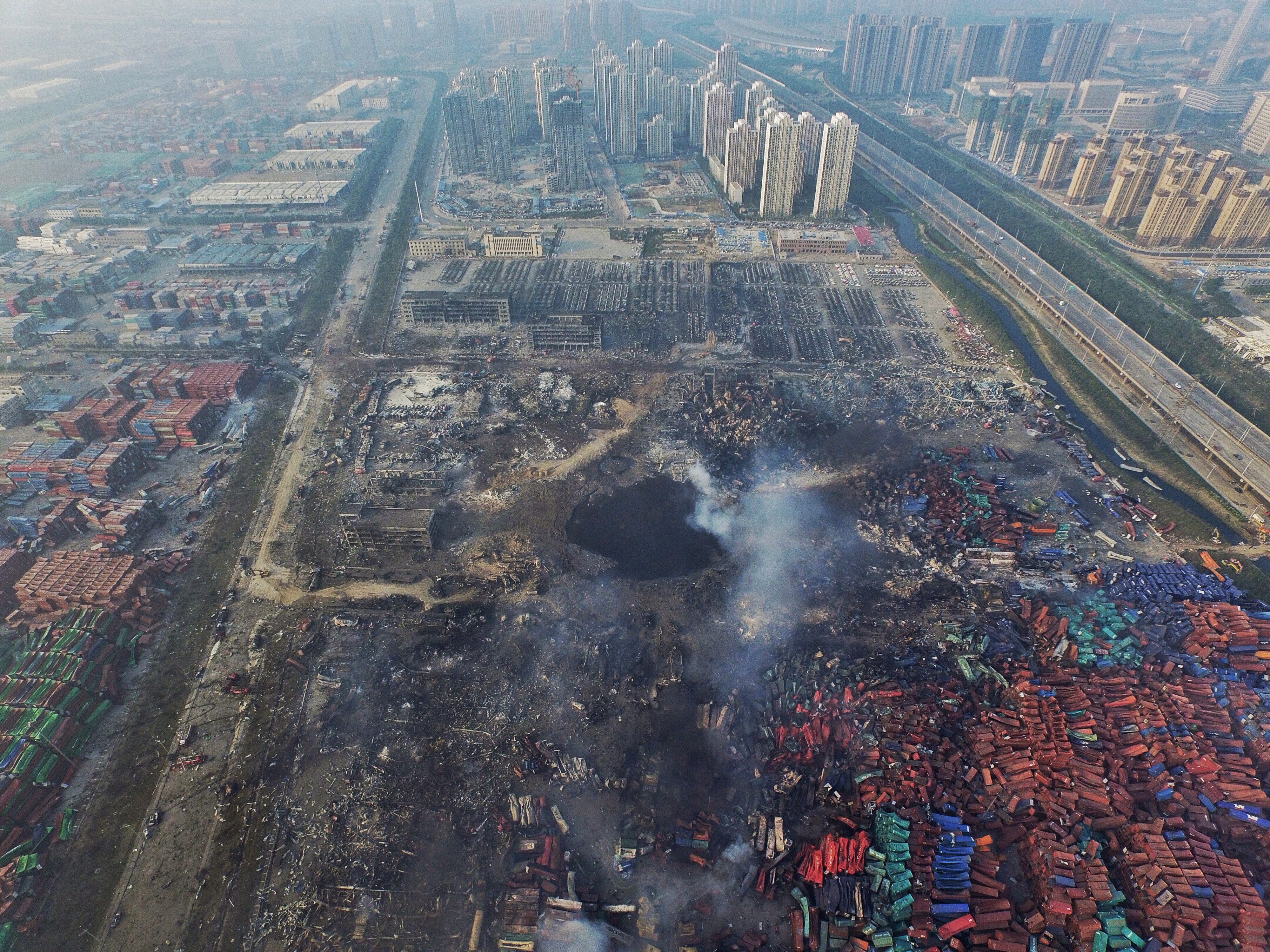 epa04899810 (FILE) A file picture dated 15 August 2015 shows an aerial view of a large hole in the ground in the aftermath of a huge explosion that rocked the port city of Tianjin, China. Eleven port and transport officials are being prosecuted for the chemical blasts that killed 139 people and left 34 missing in Tianjin, China, state media reported on 27 August 2015. Officials working for the port company, transport, work safety, land and customs departments are being probed for 'dereliction of duty' and 'abuse of power,' media reported. Tianjin Ruihai International Logistics is suspected of illegally storing dangerous materials. Twin blasts ripped through the Binhai New Area in the northern Chinese port of Tianjin on 12 August 2015. The cause is still under investigation. EPA/STR CHINA OUT