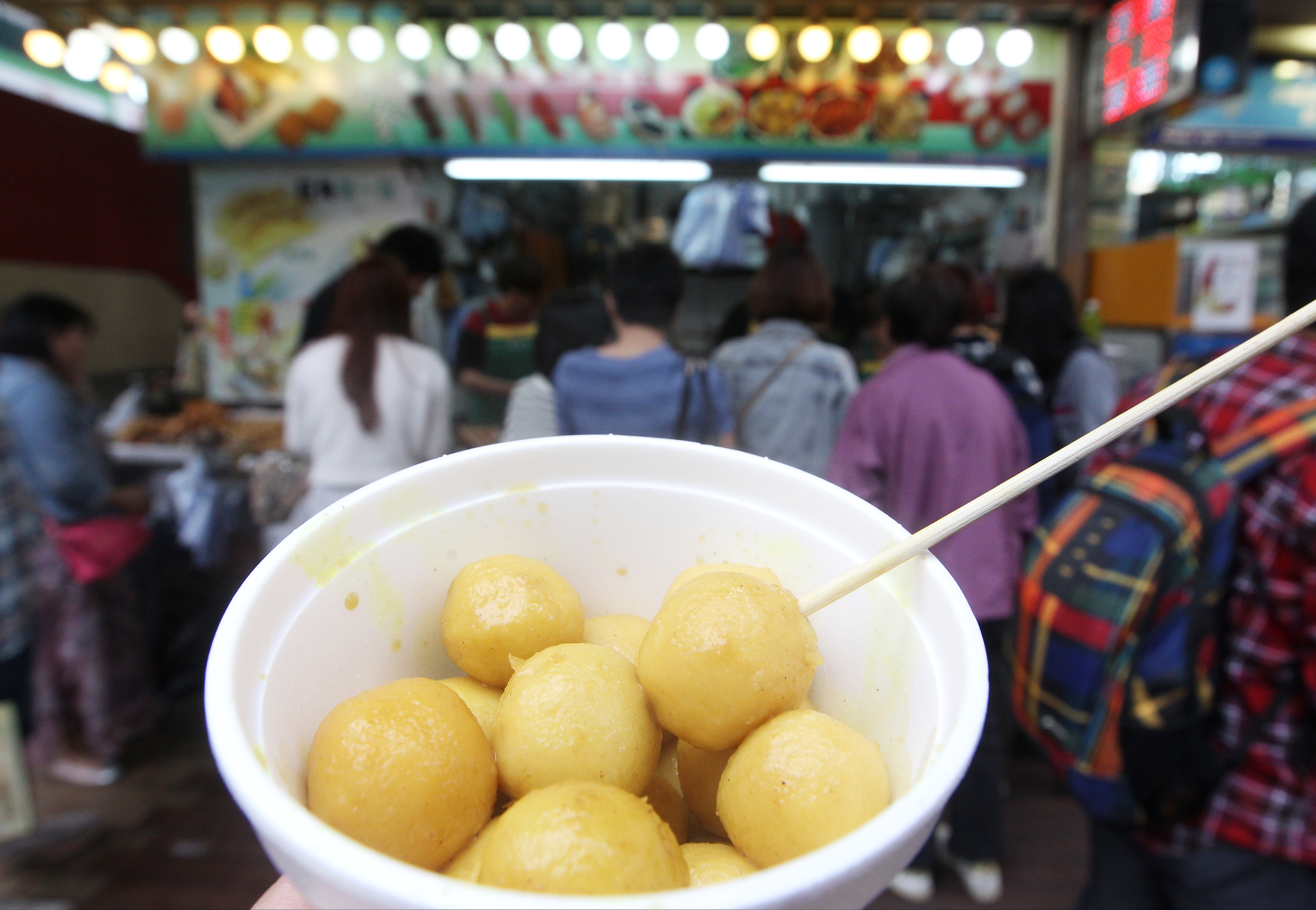 Customers buy fishballs (HK$20 minimum consumption) in a snack shop at the junction of Argyle Street and Portland Street, Mongkok. 07FEB14