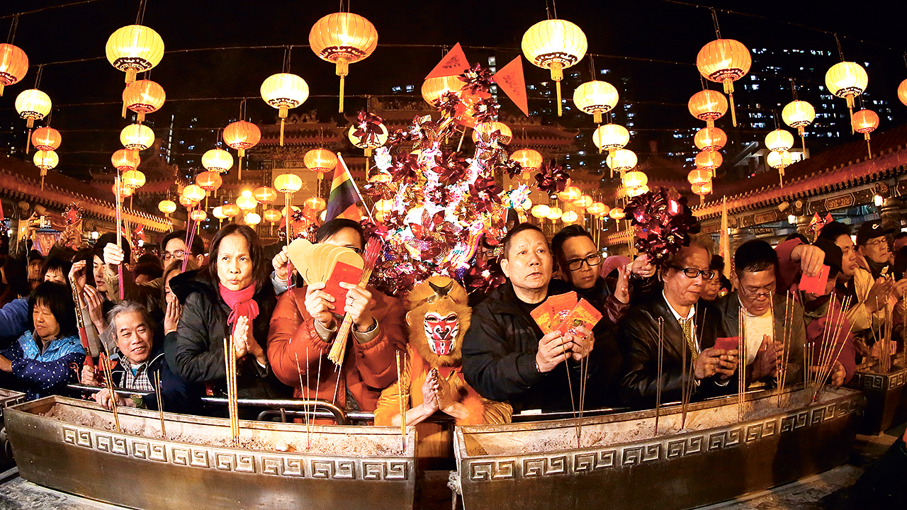 Worshippers including ex-actress Lana Wong Hai-wai (centre) dressed in monkey costume offer the first incense at Wong Tai Sin Temple on Lunar New Year's Eve. 07FEB16 SCMP/Nora Tam