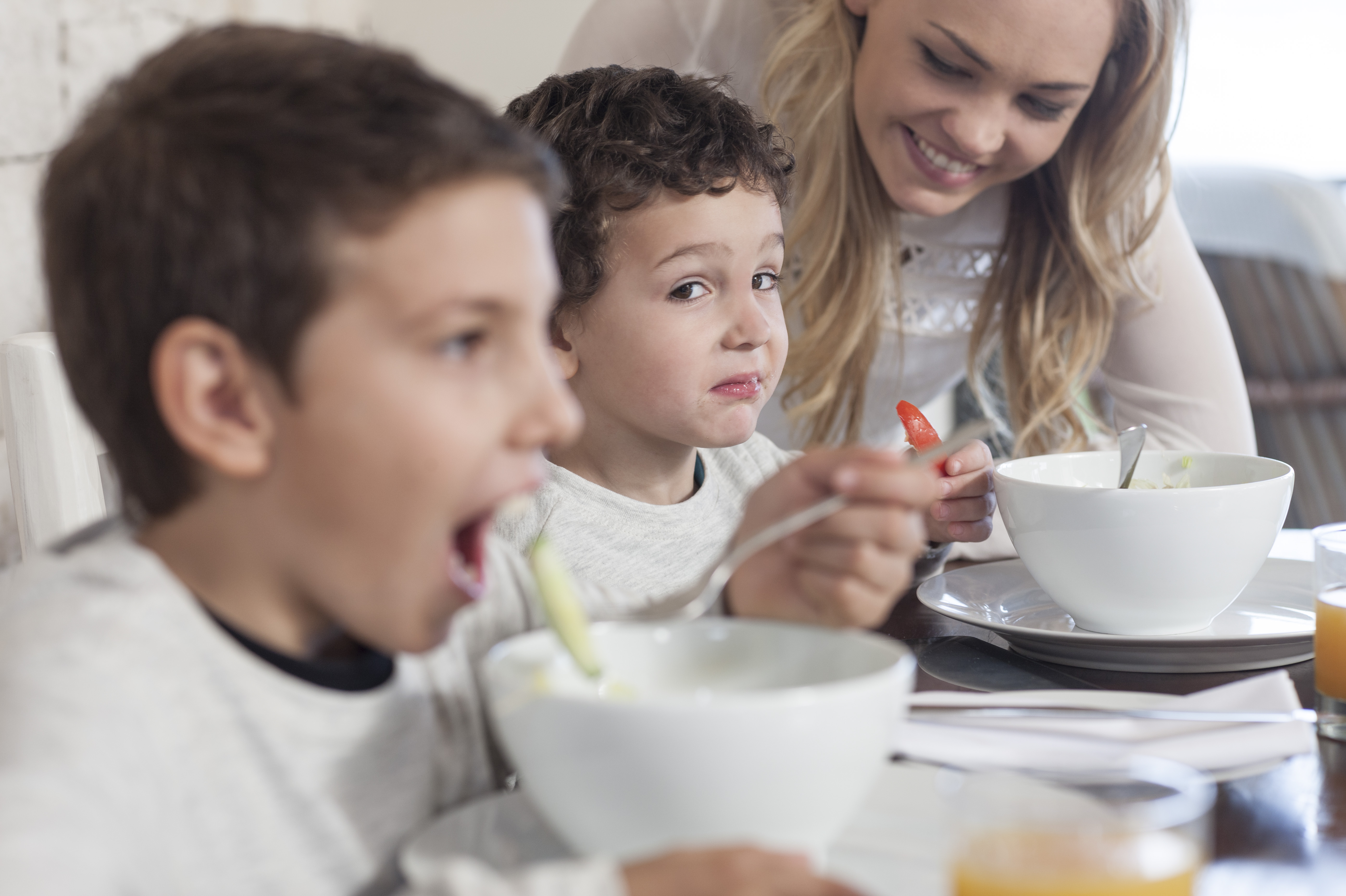 Boy with family having lunch in dining room refusing healthy food. Photo / Corbis [16FEBRUARY2016 FEATURES FAMILY LINES16]