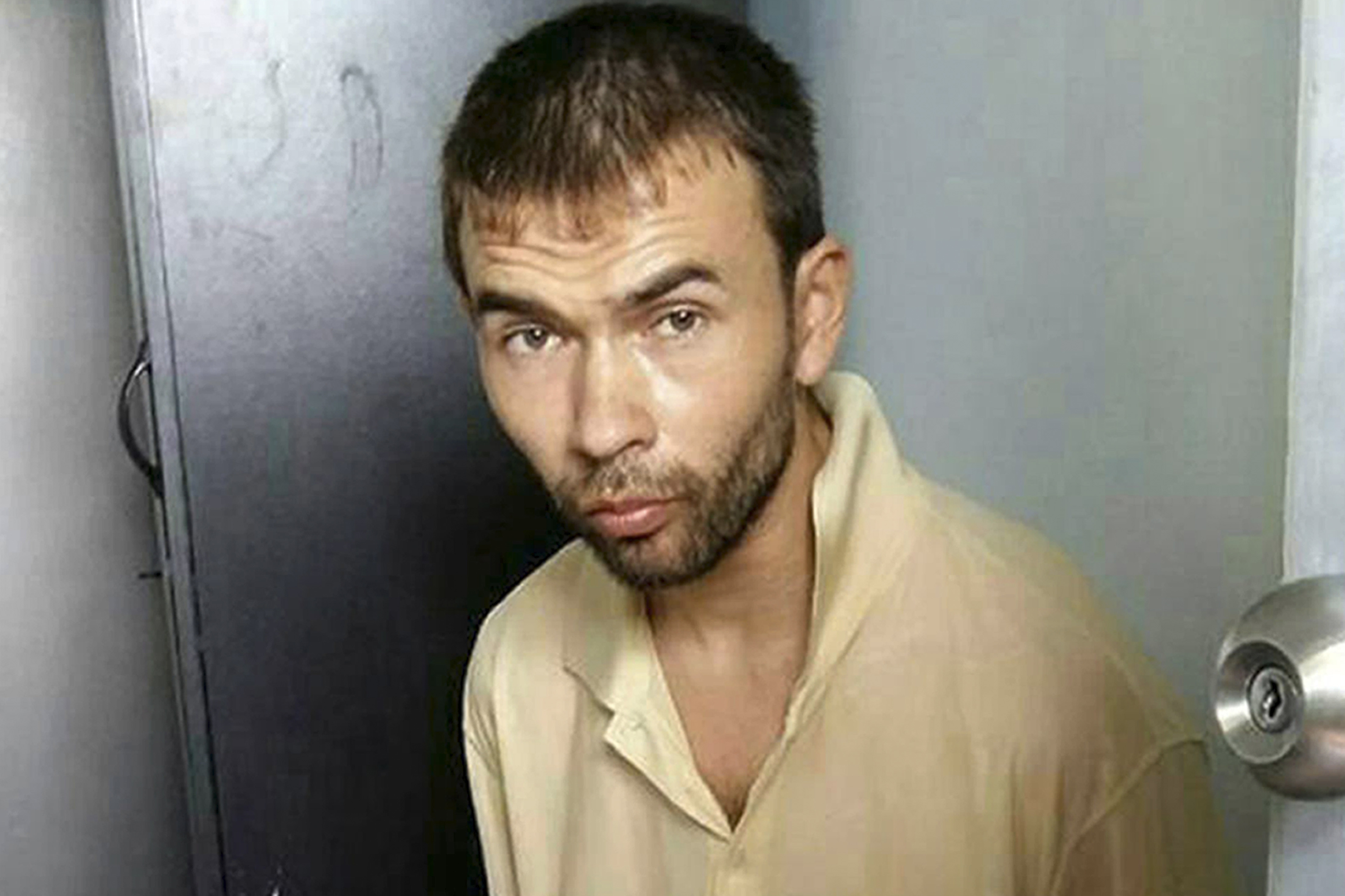 This image released by the Royal Thai Police shows a man who was arrested at an apartment on Saturday, Aug. 29, 2015, in Bangkok, Thailand, along with evidence police said included bomb-making equipment and stacks of passports. Thai investigators said they have linked this man to the Erawan Shrine bombing on Aug. 17. (Royal Thai Police via AP)