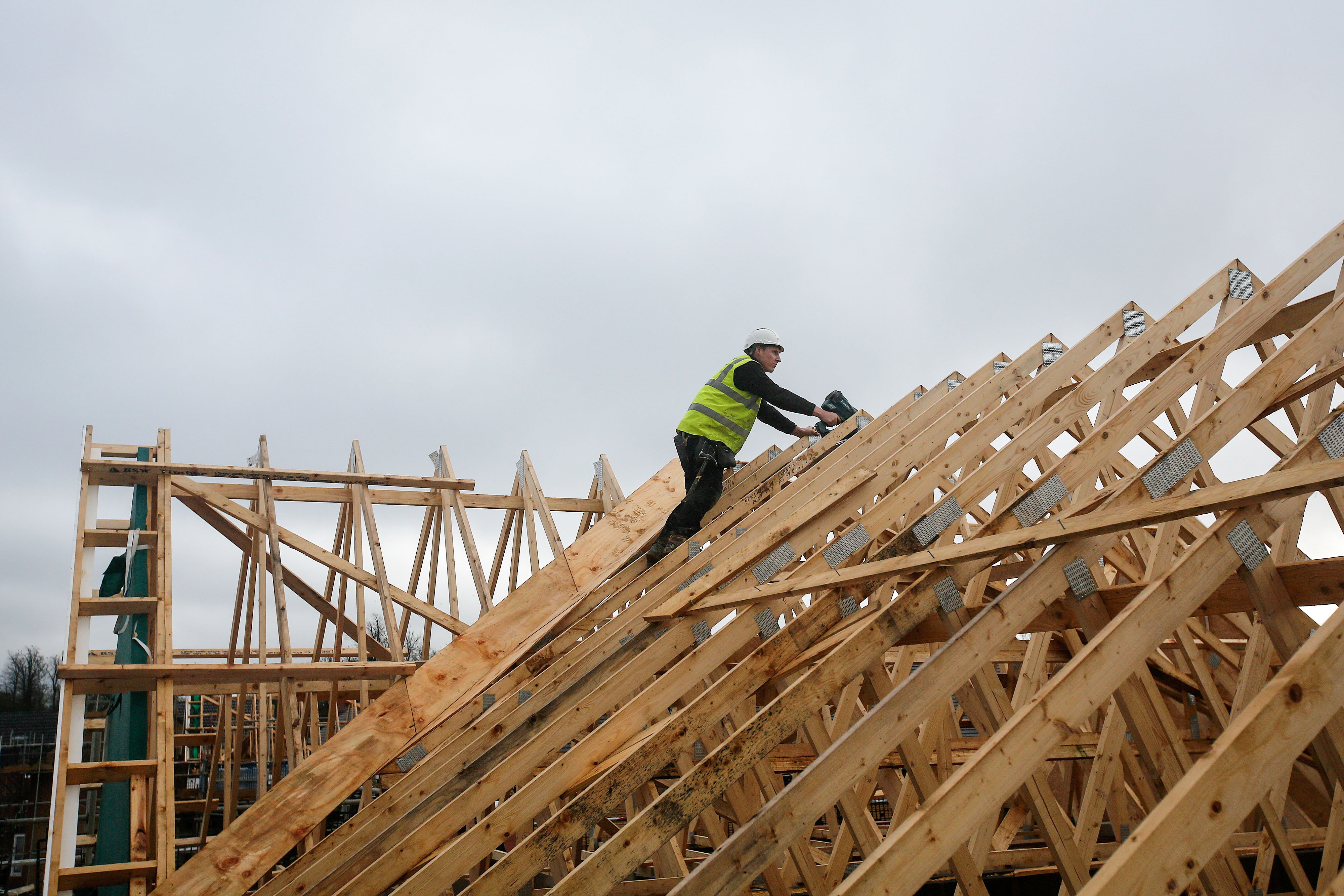 A builder climbs across roof timbers at a Persimmon Plc residential property construction site in Cranfield, U.K., on Tuesday, Jan. 6, 2016. The average price of a home rose 0.8 percent to 196,999 pounds ($292,100) from November, the most since April, Nationwide Building Society said in a statement released at the end of December. Photographer: Simon Dawson/Bloomberg ORG XMIT: 598456449