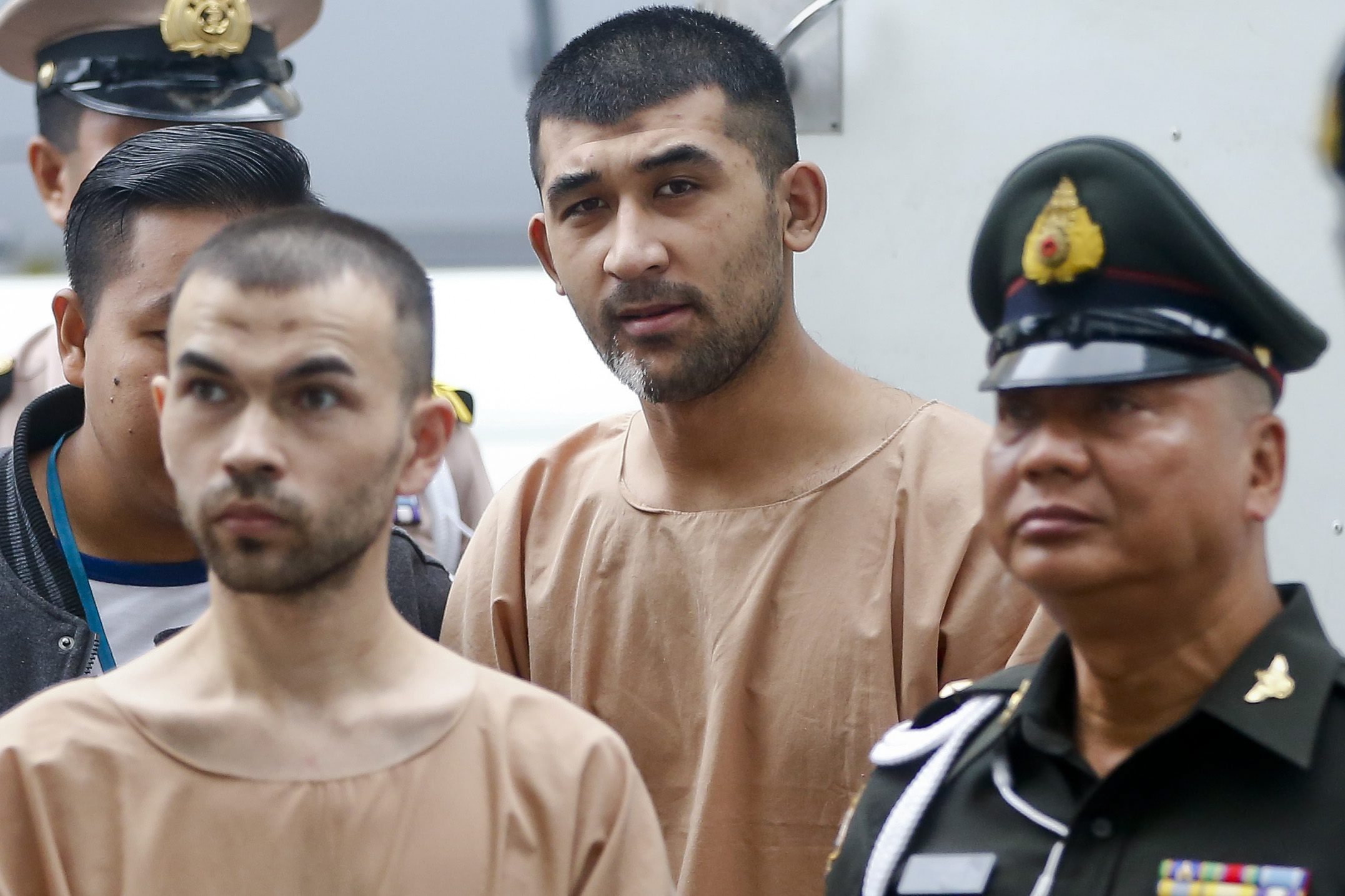epa05163903 Erawan Shrine's bombing main suspect, identified by Thai police as Adem Karadag (L, front), and Yusufu Mieraili (C, back) are escorted by officers and prison personnel to the Military Court, in Bangkok, Thailand, 16 February 2016. A military court in Thailand on 24 November 2015, charged two men accused of carrying out a deadly explosion in central Bangkok in August. The bomb attack at a Hindu shrine killed 20 people, mostly tourists, and injured more than 120. Adem Karadag and Yusufu Mieraili each face 10 charges, including premeditated murder, but not terrorism, Thai media reported. The two suspects arrived at the military court in Bangkok on 16 February 2016, in handcuffs and escorted by the police. Karadag, identified initially by the name Bilal Muhammed, and Mieraili have been detained at an army base since they were arrested in August and September, respectively. Adem Karadag has retracted his confession of being involved in the attack claiming he was coerced into con