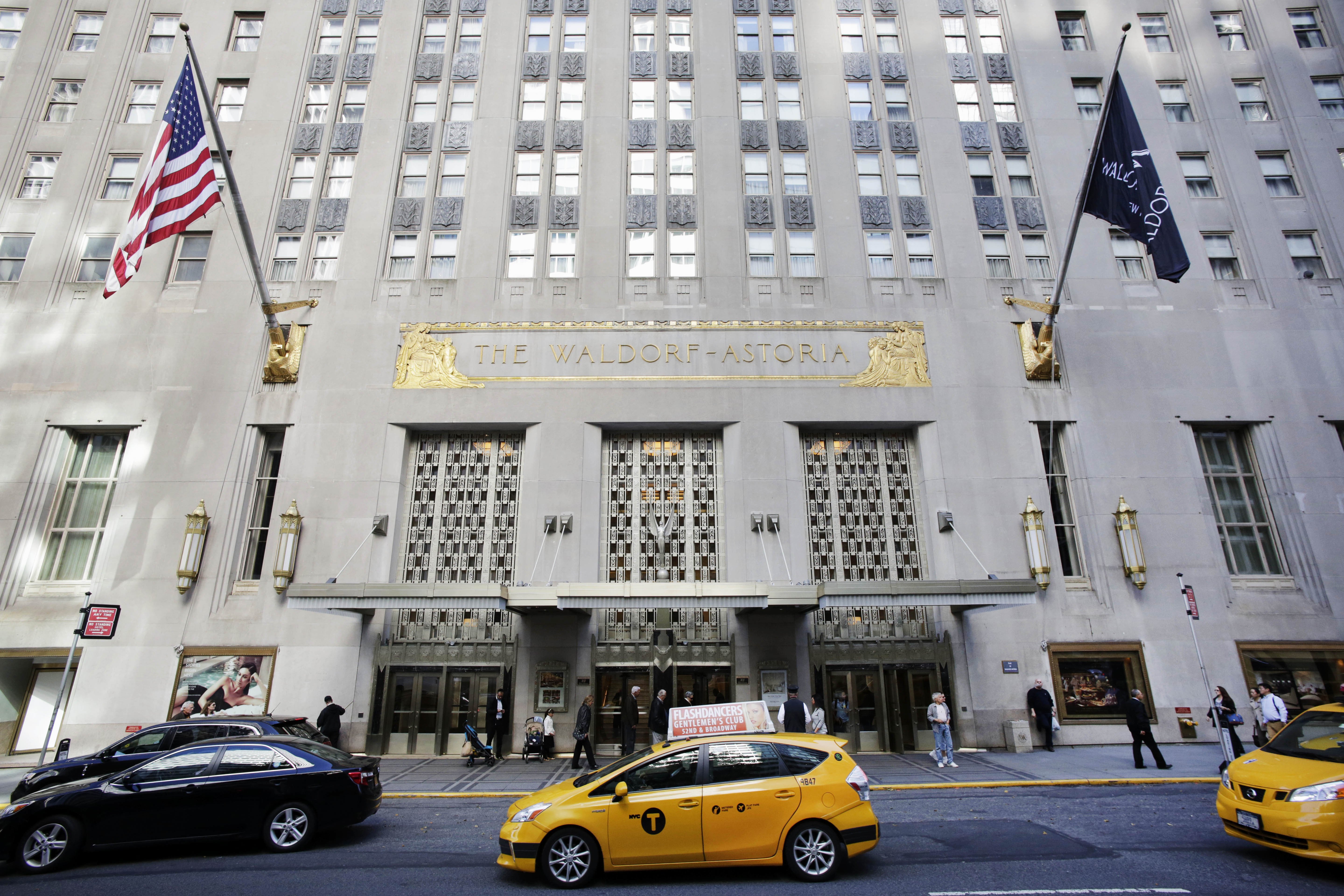FILE - In this Oct. 6, 2014 file photo, a taxi passes in front of the fabled Waldorf Astoria hotel in New York. The State Department will abandon decades of tradition at the annual UN General Assembly this fall by setting up shop in a hotel other than New Yorks famed Waldorf-Astoria, which was purchased last year by a Chinese company. (AP Photo/Mark Lennihan, File)