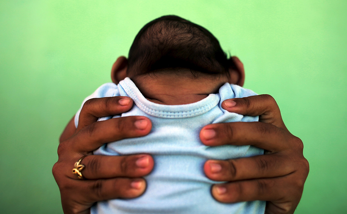 Jackeline, 26, holds her son who is 4-months old and born with microcephaly, in front of their house in Olinda, near Recife, Brazil, February 11, 2016. Recent laboratory analyses identified Zika virus infections in three people who died in Brazil last year, the health ministry said on Thursday, although authorities could not confirm that Zika alone was responsible for their deaths. REUTERS/Nacho Doce TPX IMAGES OF THE DAY