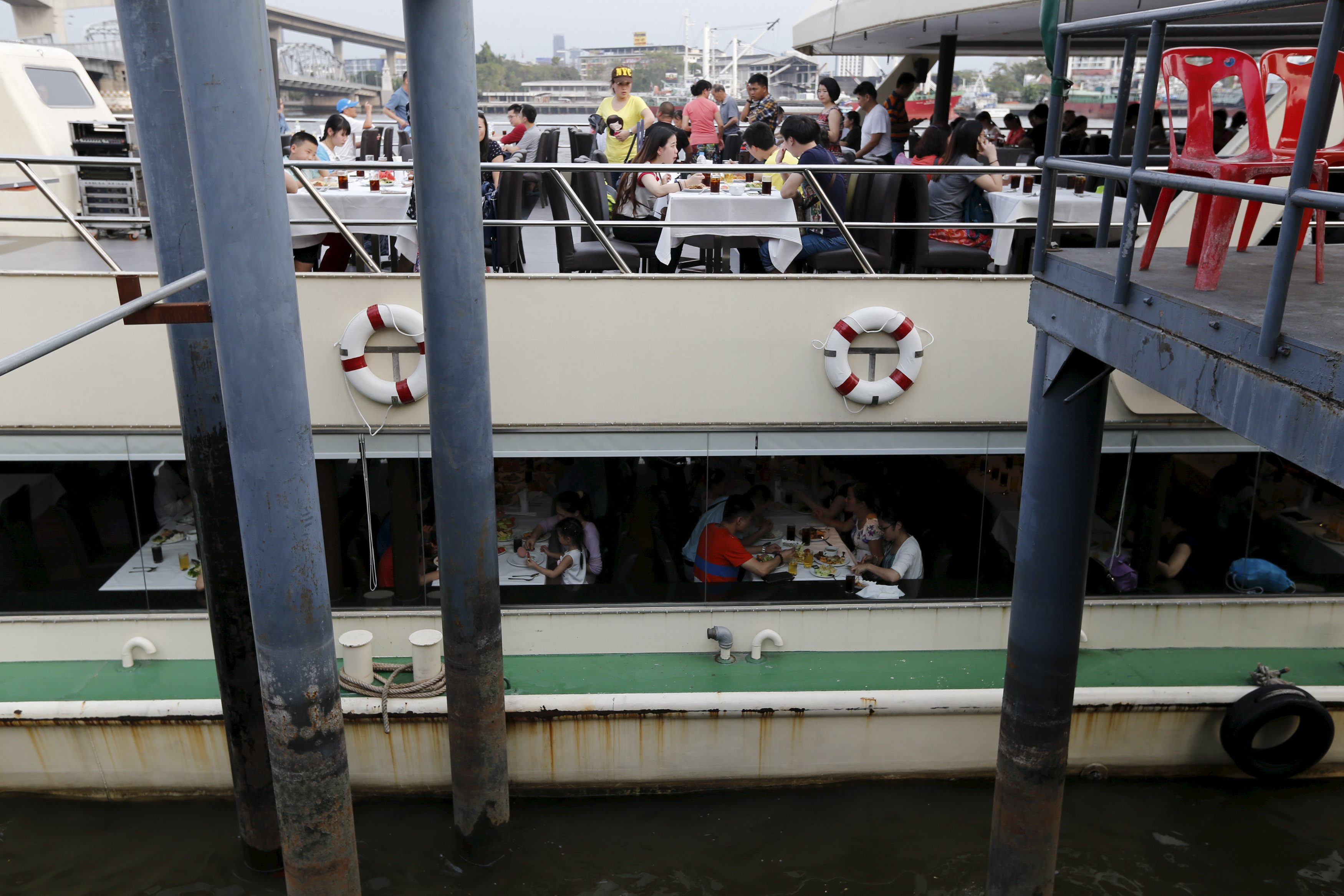 Chinese tourists dine onboard a boat at a pier at Chao Phraya River in Bangkok February 16, 2016. The perpetrators of last year's deadly explosion at a Bangkok shrine originally chose a pier packed with Chinese tourists as their primary target and had amassed enough chemicals to make 10 equally powerful bombs, the chief of Thailand's police bomb squad told Reuters. Picture taken February 16, 2016. REUTERS/Jorge Silva