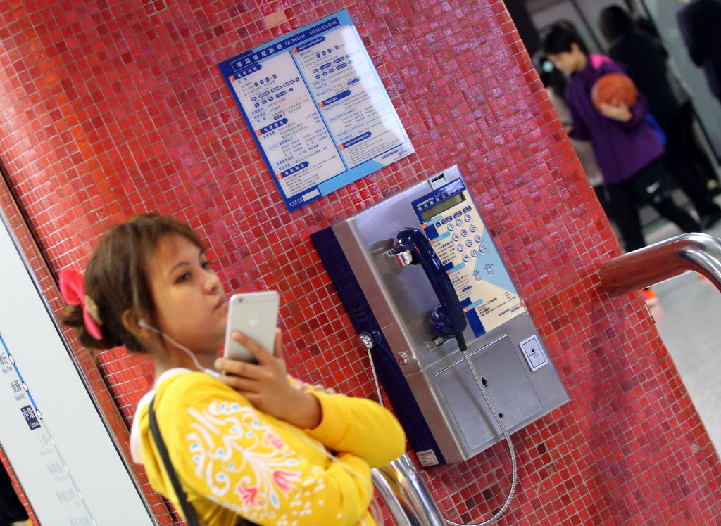 A traveller with a smartphone has no need for the public payphone at an MTR station. Photo: Felix Wong.