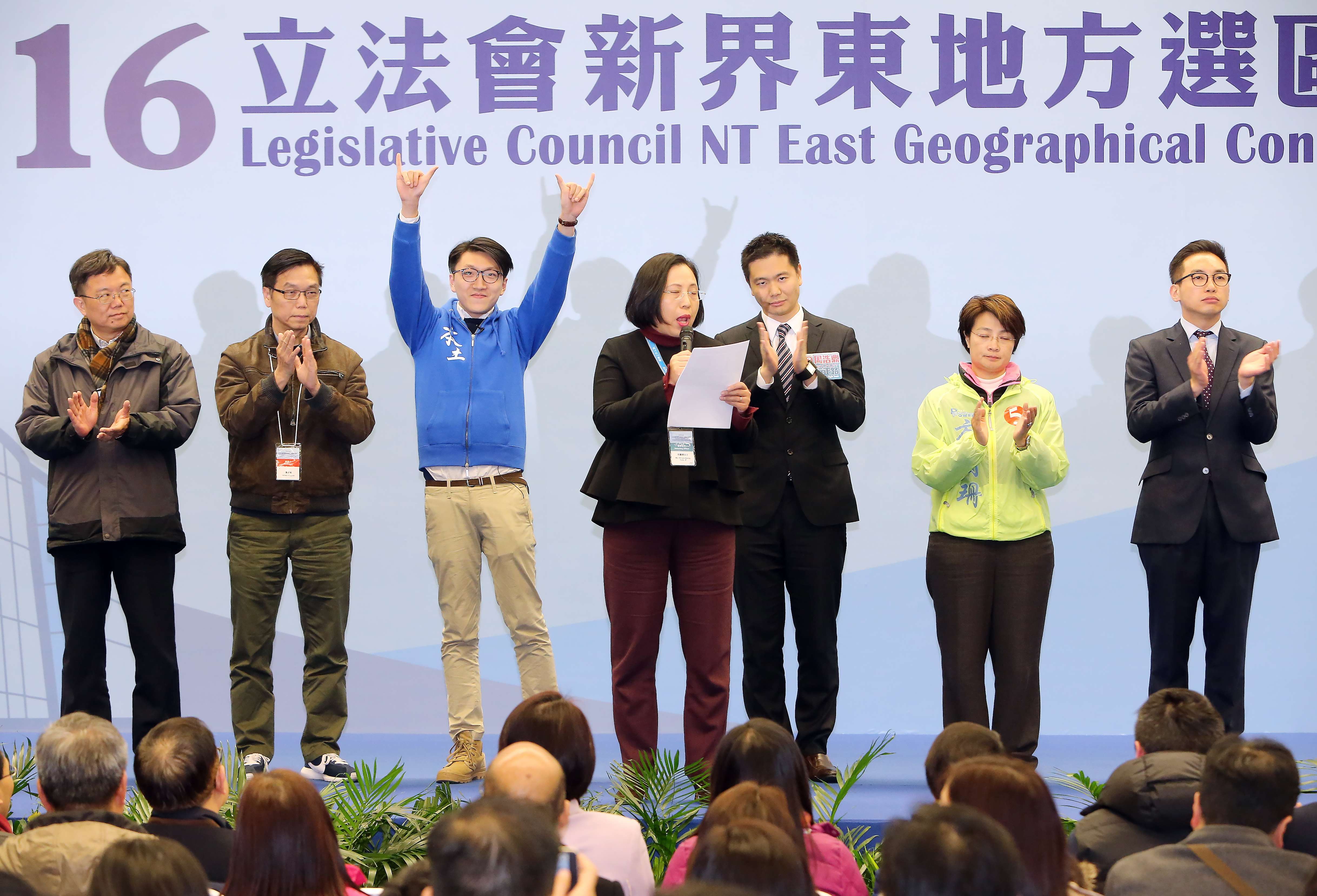 Edward Leung of Hong Kong Indigenous raises his hands in greeting as the Electoral Affairs Commission returning officer announces the results of the New Territories East by-election, with the other candidates looking on. Photo: Dickson Lee
