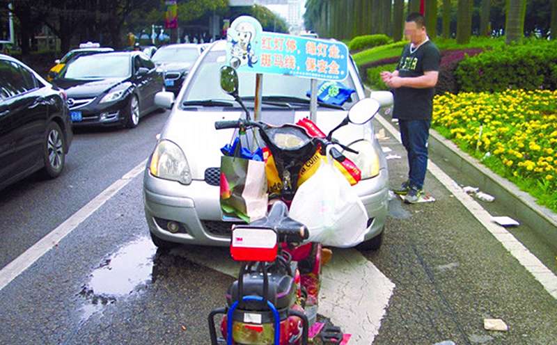 An electric bicycle is parked in front of a Toyota car in Zhangshan following the alleged revenge attack. Photo: Zhongshan Daily