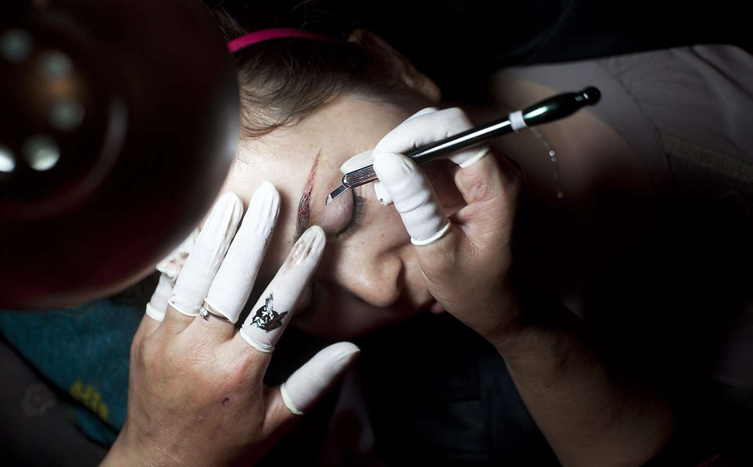 A woman has her eyebrows tattooed at a beauty, hairdressing and cosmetics expo in Beijing. Photo: EPA
