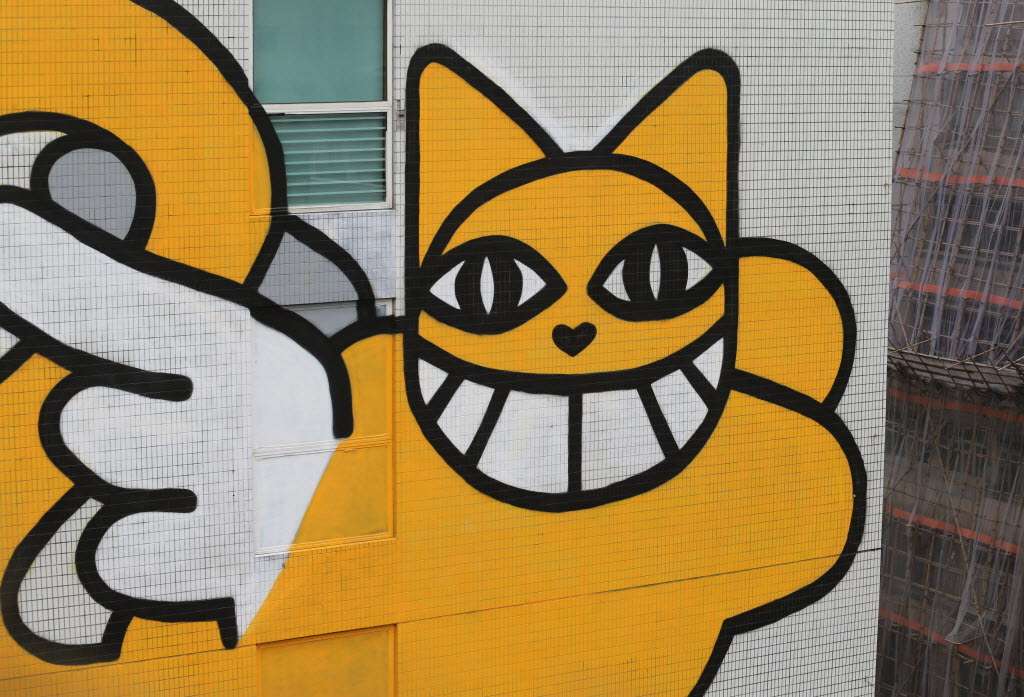 The yellow grinning cat on the side of Hotel Jen. Photo: Felix Wong