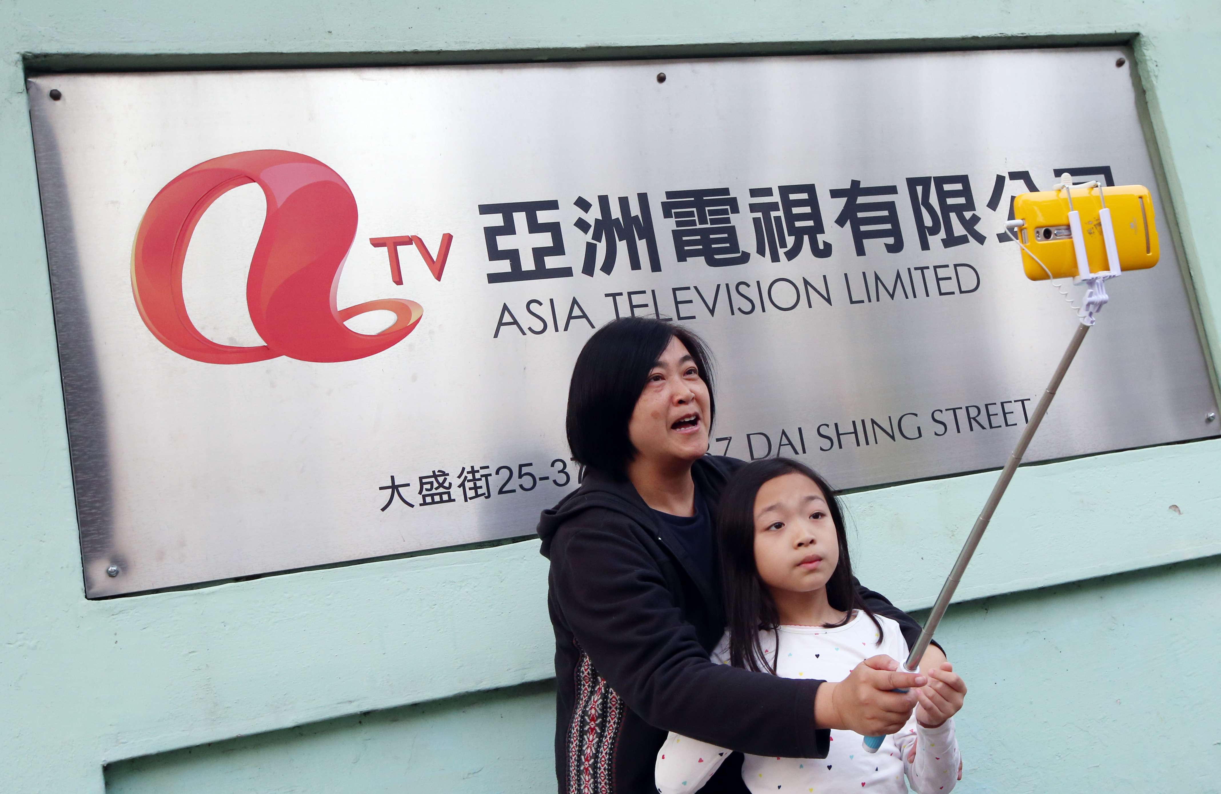 A woman takes a selfie outside the ATV headquarters in Tai Po hours before the 59-year-old broadcaster went off air. Photo: David Wong