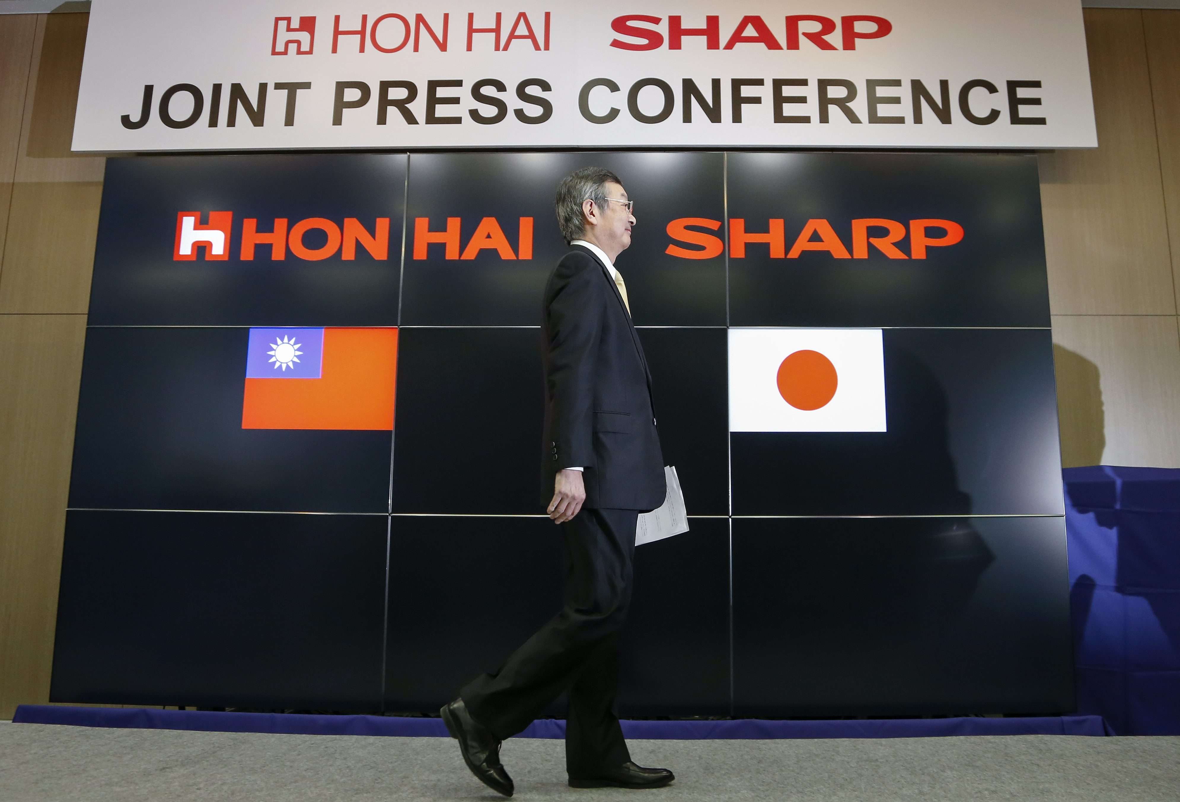 Kozo Takahashi, president of Sharp Corp, walks past a podium after speaking following a takeover agreement with Taiwan's Hon Hai Technology Group in Osaka. Photo: EPA
