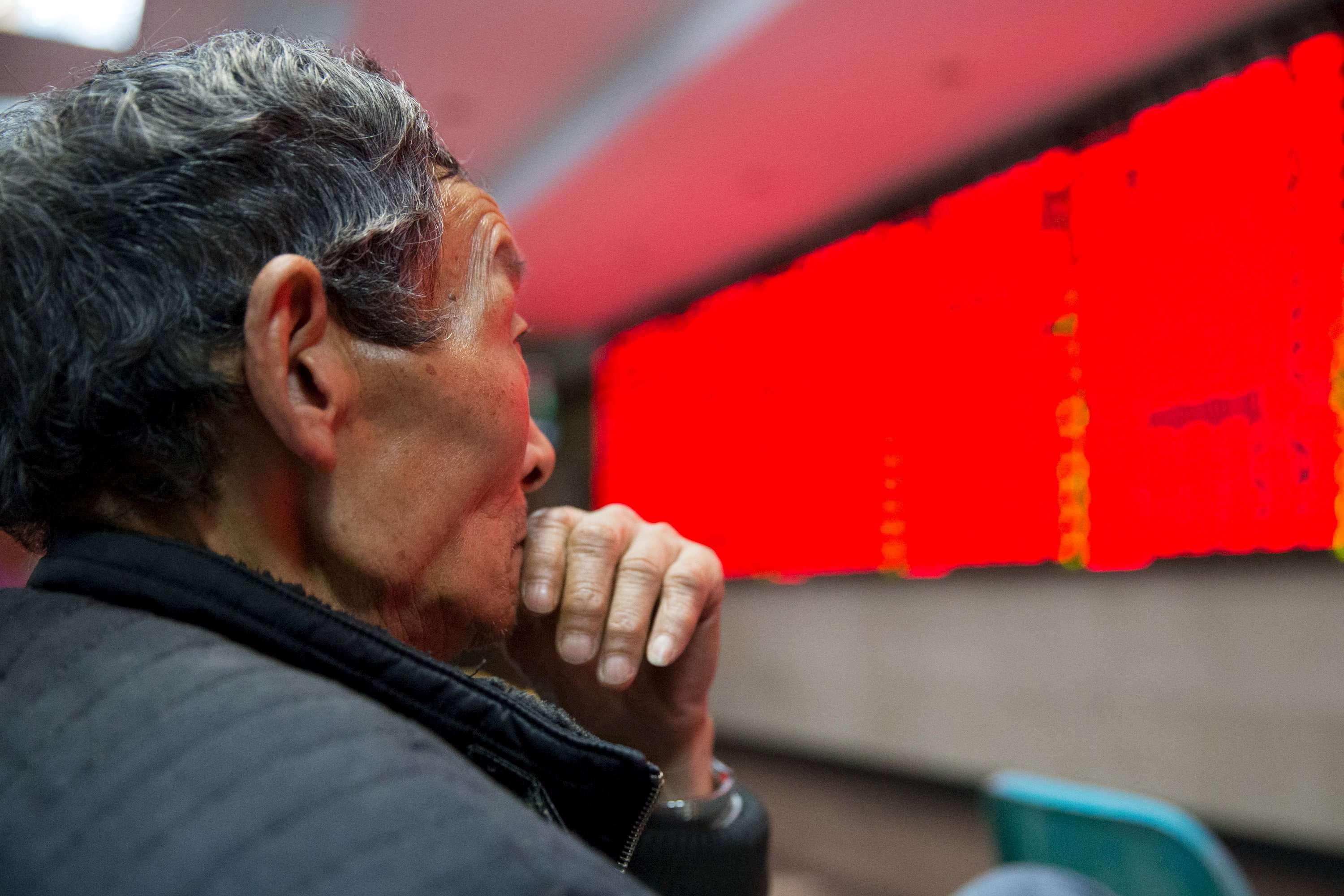 An investor looks at an electronic screen showing stock information at a brokerage house in Nanjing. Photo: Reuters.