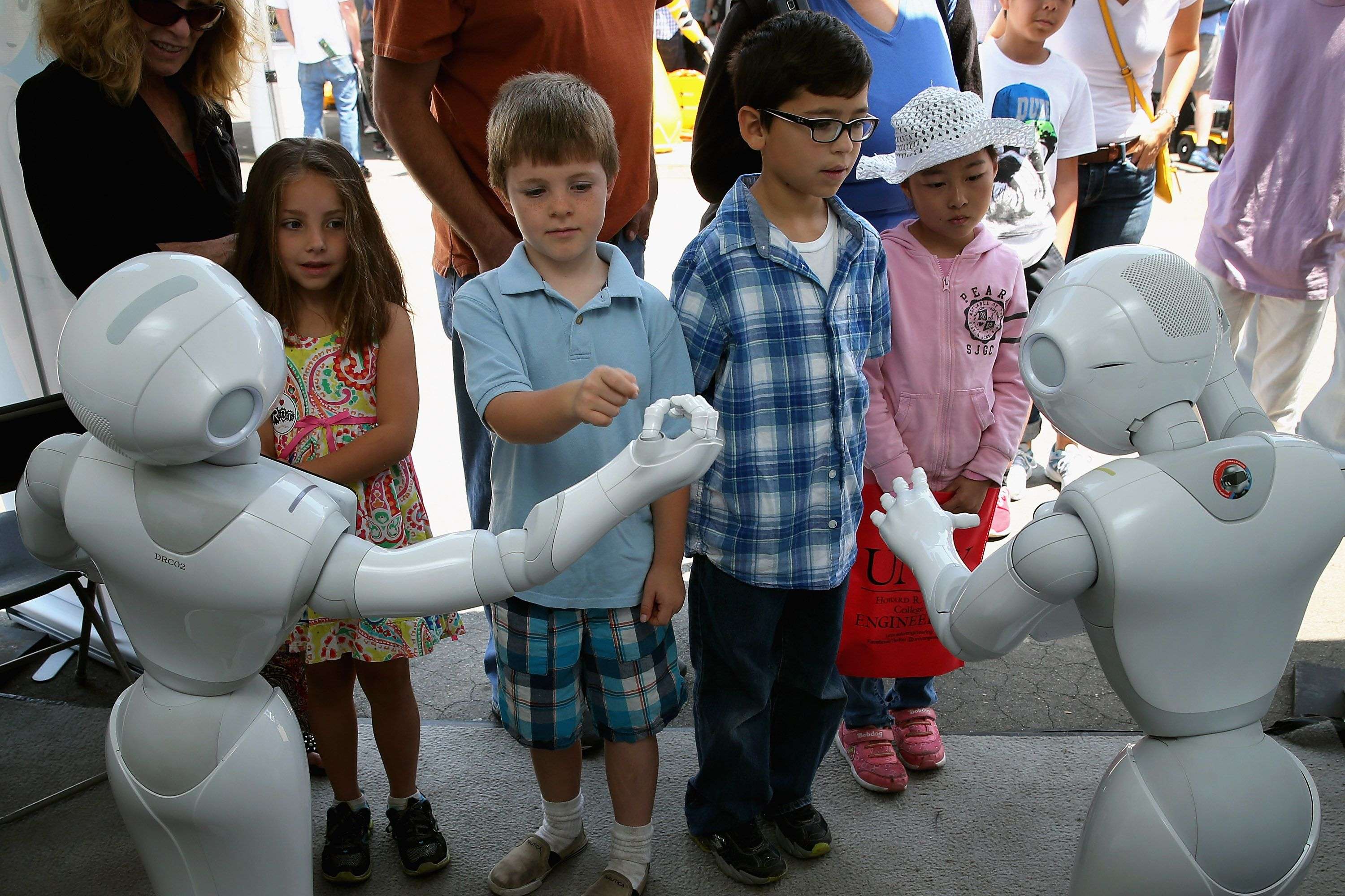 POMONA, CA - JUNE 06: Children interact with Aldebaran's Pepper robot during the Defense Advanced Research Projects Agency (DARPA) Robotics Challenge Expo at the Fairplex June 6, 2015 in Pomona, California. Organized by DARPA, the Pentagon's science research group, 24 teams from aorund the world are competing for $3.5 million in prize money that will be awarded to the robots that best respond to natural and man-made disasters. Chip Somodevilla/Getty Images/AFP == FOR NEWSPAPERS, INTERNET, TELCOS & TELEVISION USE ONLY ==