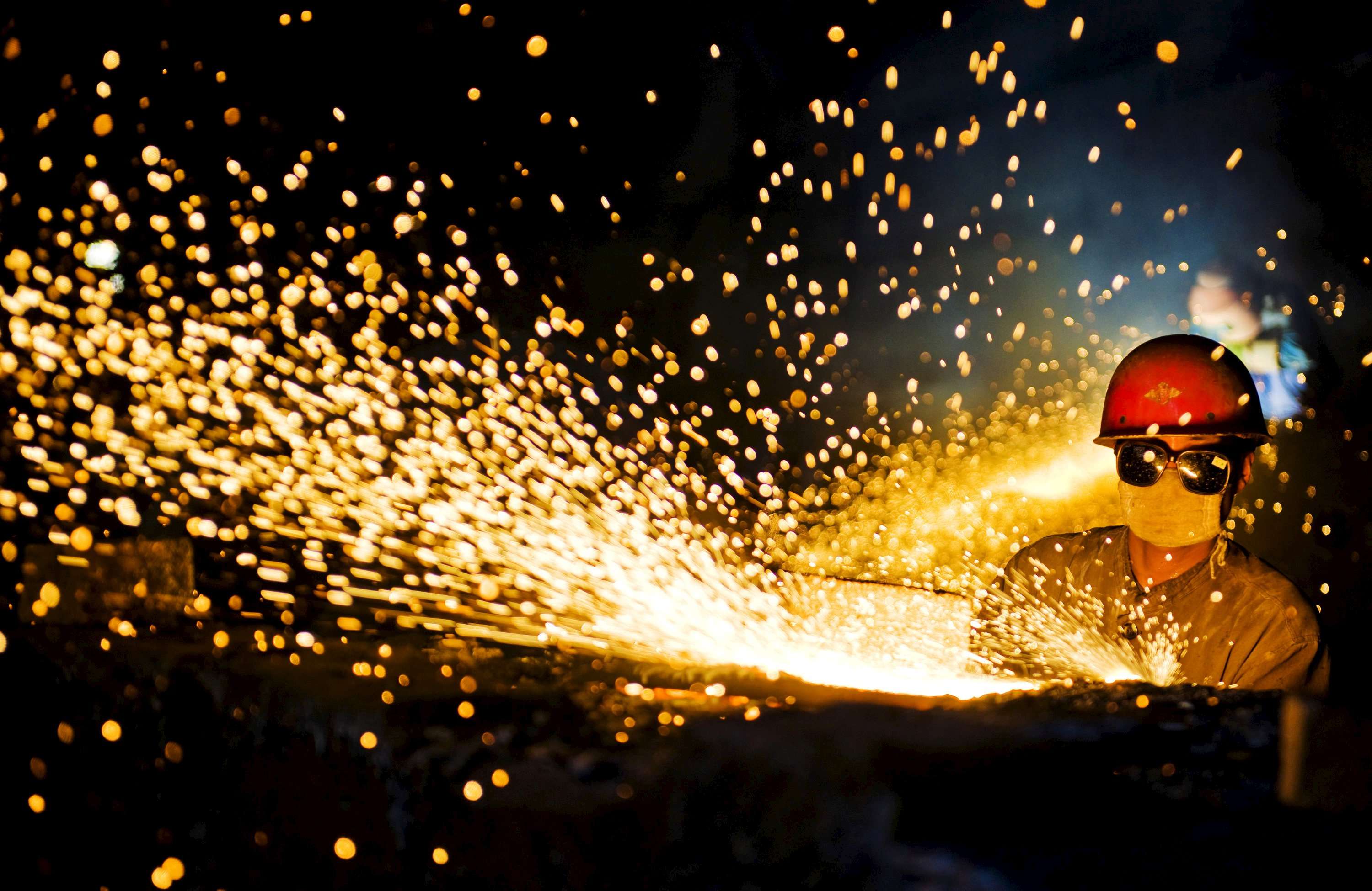 A worker wearing protective glasses welds steel products at a factory in Luoyang, Henan province. Photo: Reuters