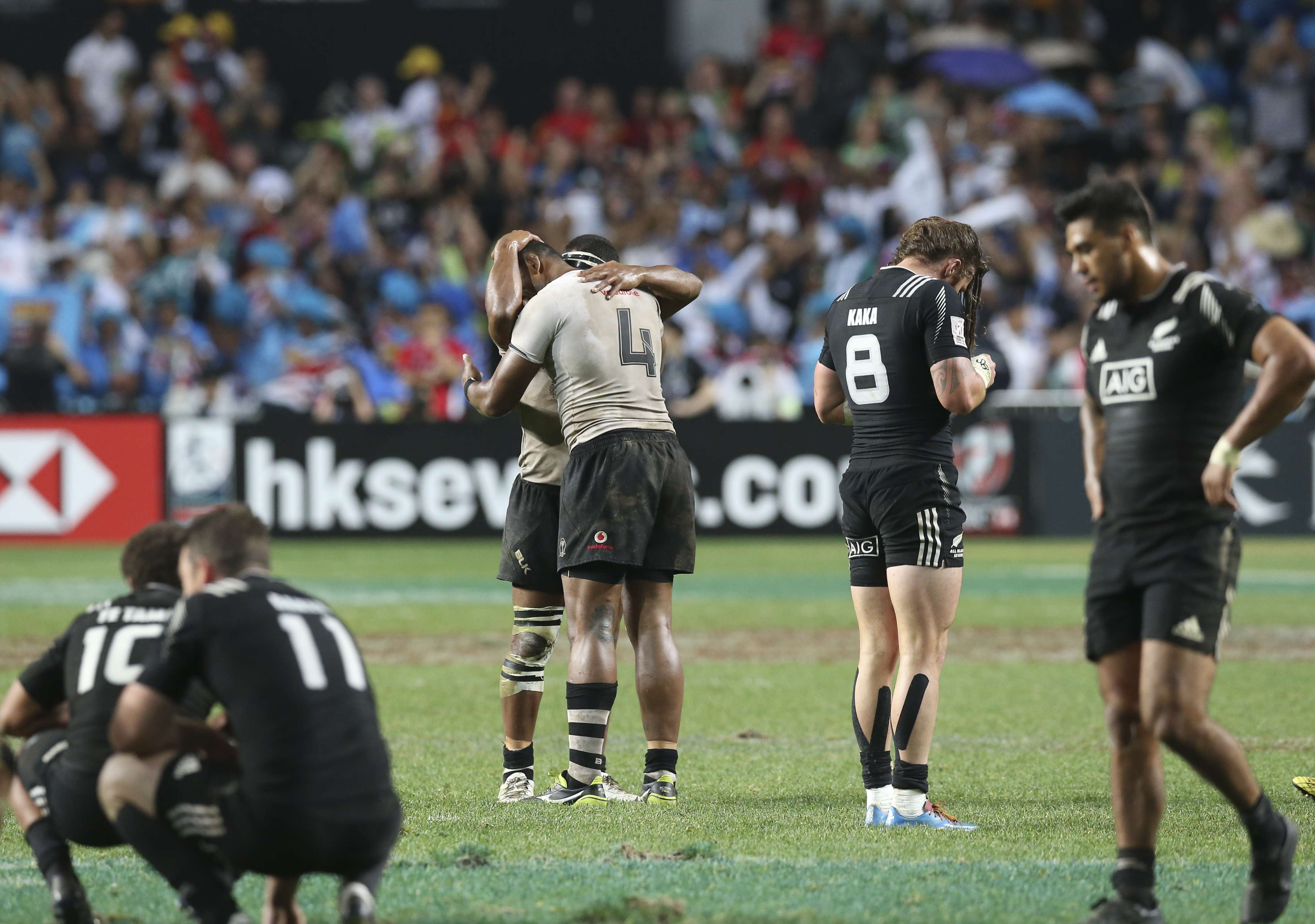 Fijians celebrates as New Zealand players react with disappointment after losing the Cup final at the Hong Kong Sevens On Sunday. Photo: K. Y. Cheng
