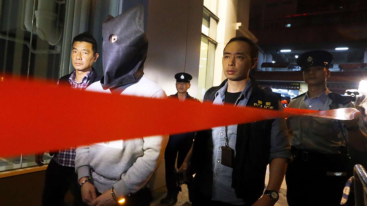 A suspect held over a murder in Tsuen Wan was escorted back to the crime scene for a reconstruction. Photo: Felix Wong