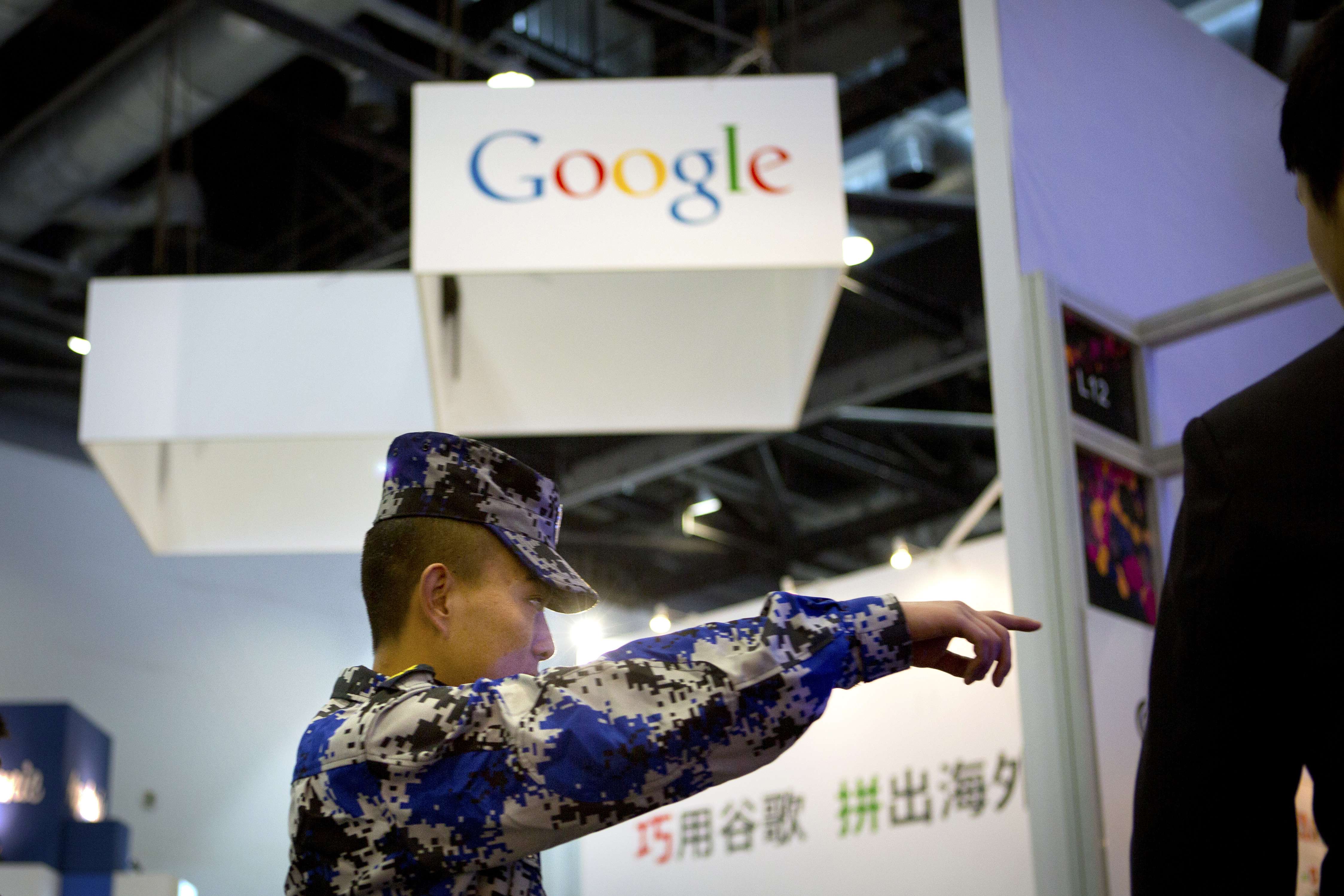 A security guard points while walking past a display booth for Google at the Global Mobile Internet Conference in Beijing. as China has run ahead of the US as a source of internet security threats due to zombie computers that are in control of hackers in the mainland. Photo: AP
