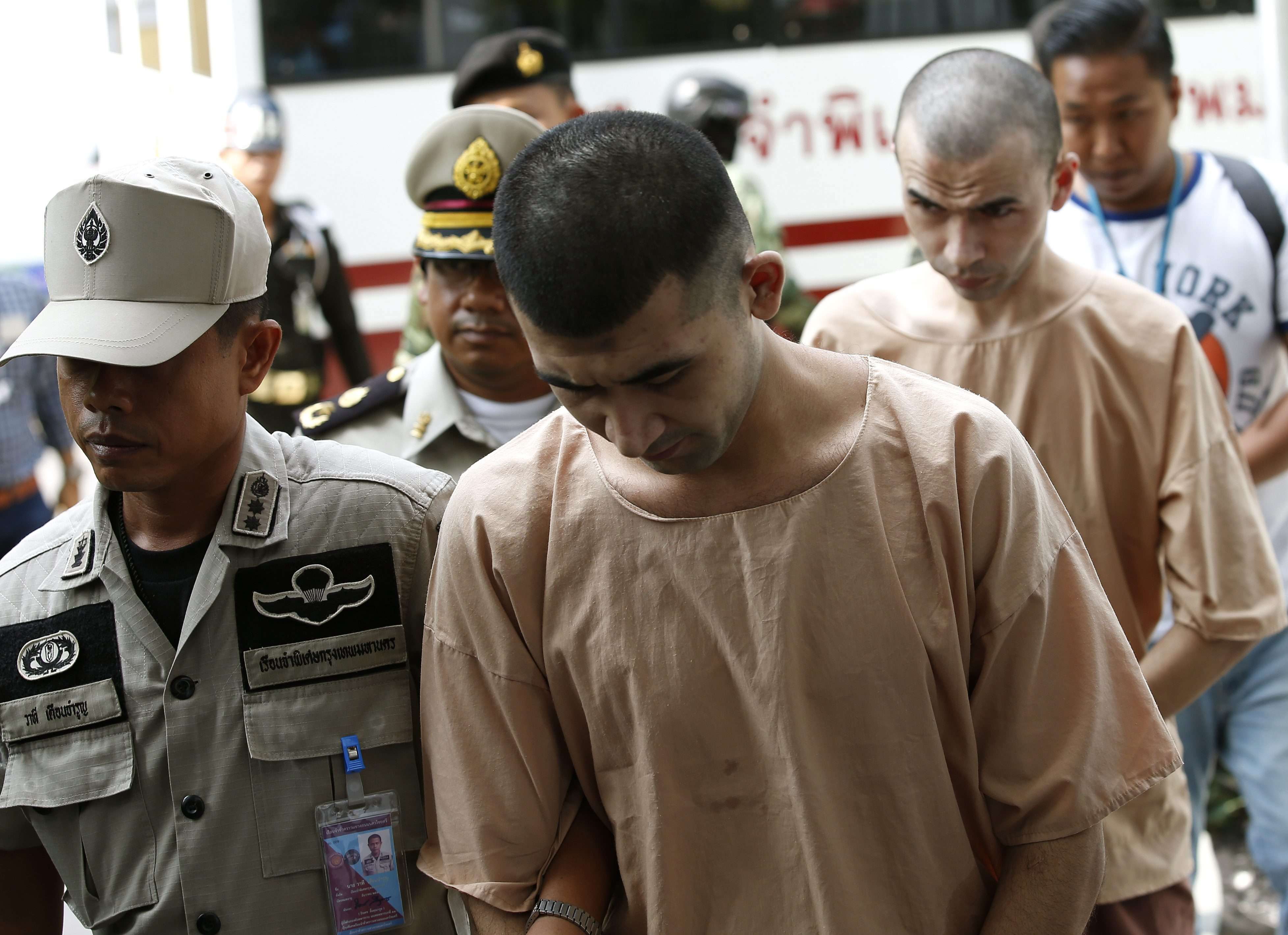 Alleged Erawan Shrine bombing suspects Yusufu Mieraili (centre) and Adem Karadag (back) are escorted by police officers and prison personnel as they arrive at the Military Court in Bangkok, Thailand on 20 April 2016. Photo: EPA