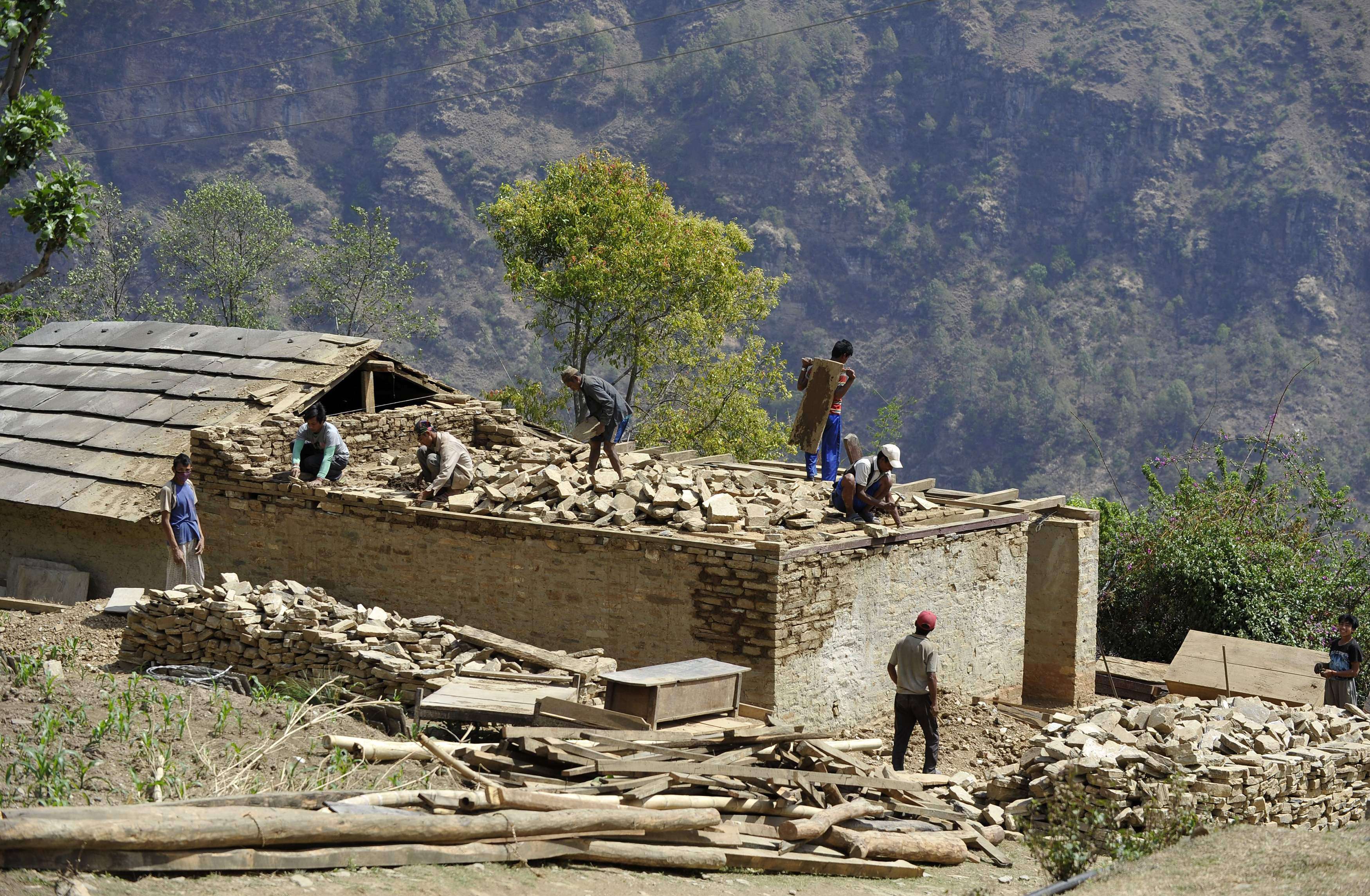 Nepalese workers rebuild in Ramechhap, an area damaged by the earthquake last year. Photo: AFP