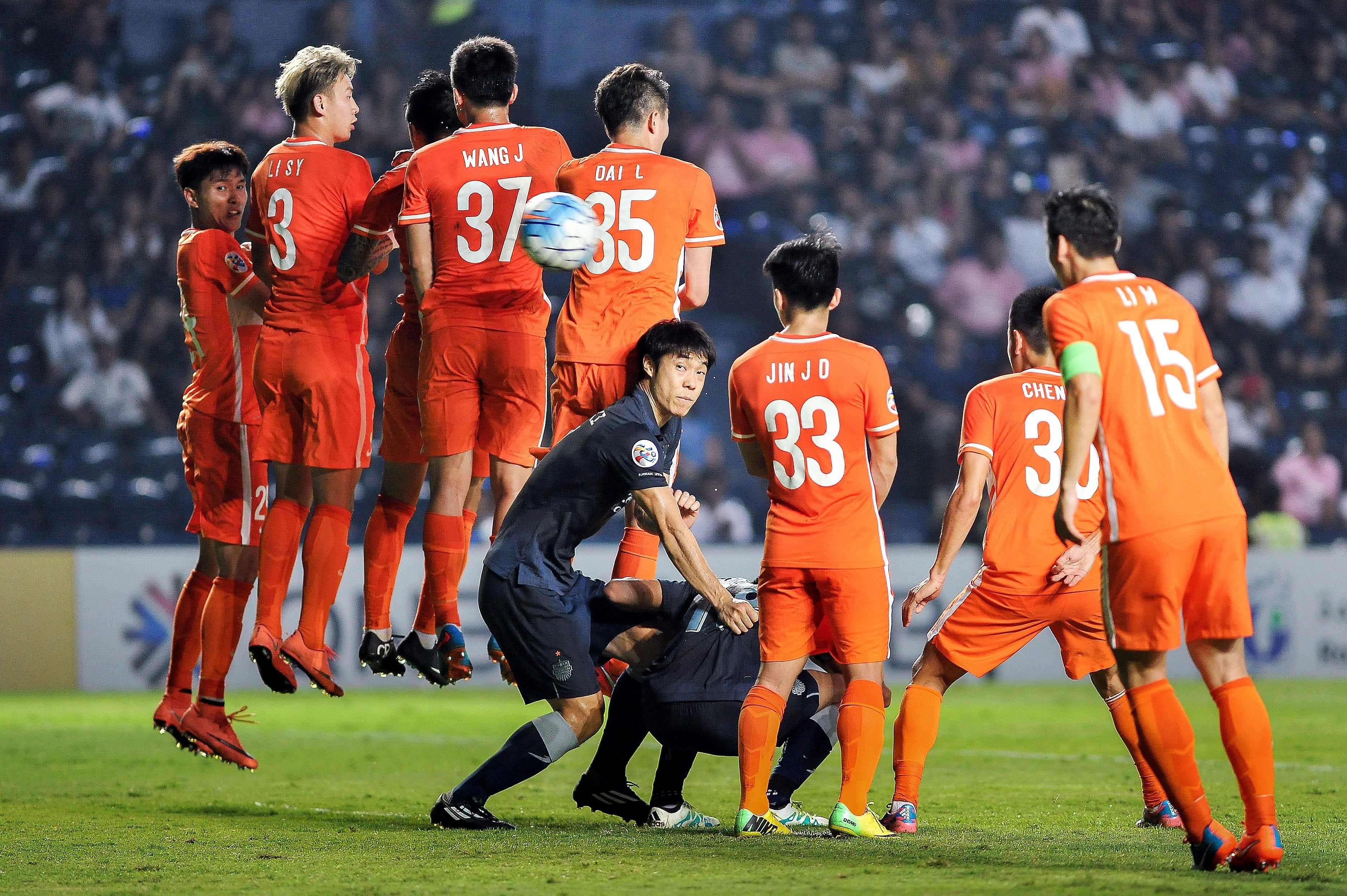 Shangdong Luneng players jump to counter a free kick by Buriram United in their AFC Champions League game in Thailand. Photo: AFP