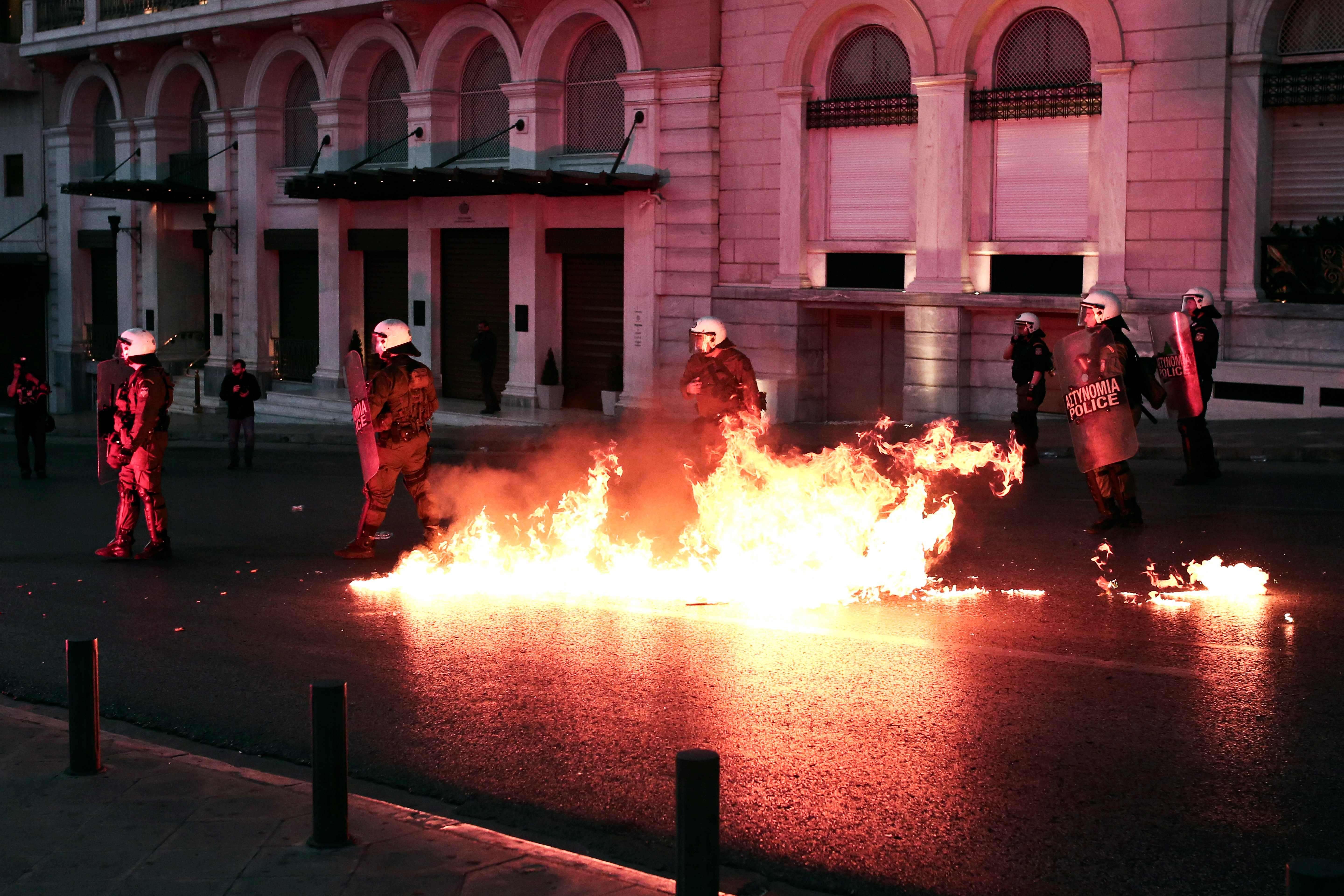 Greek police stand guard amid molotov cocktails thrown by protesters at a demonstration against reforms in Athens. Photo: AFP