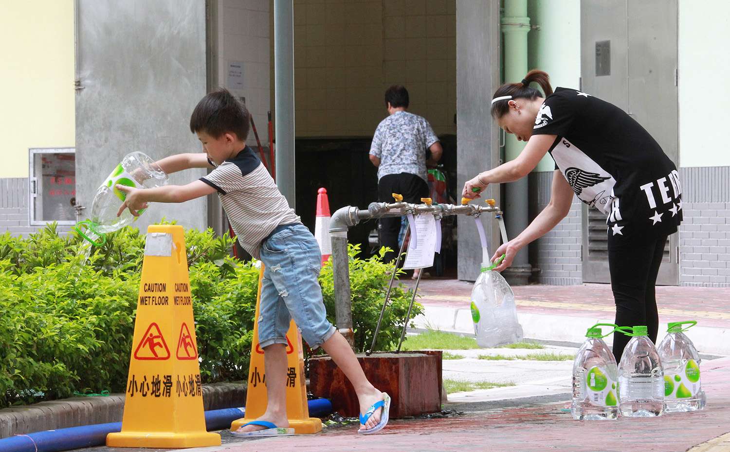 Kai Ching Estate residents collect fresh water at a temporary distribution point. Photo: May Tse