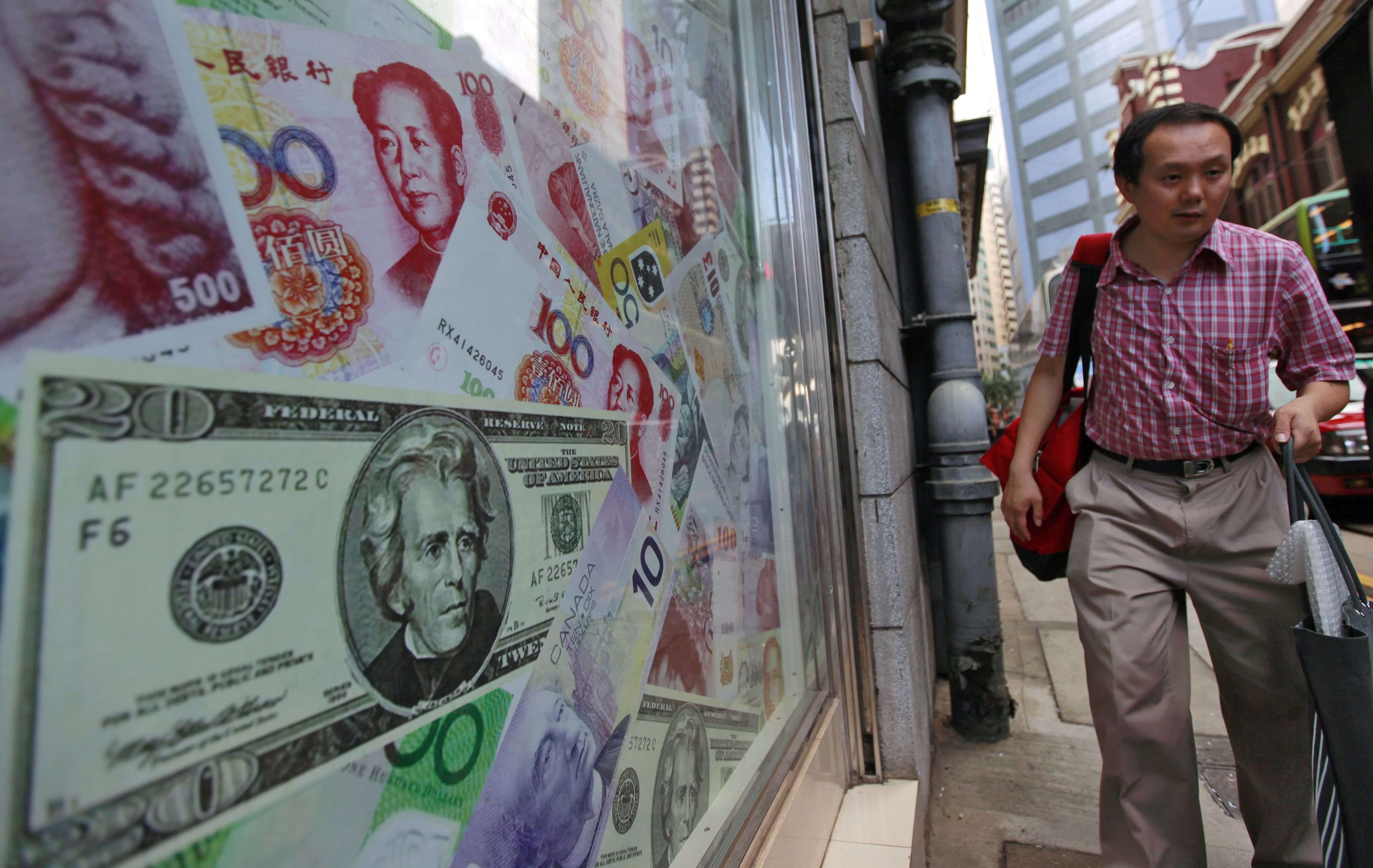 A man walks past a display of oversized banknotes outside a foreign exchange office in Hong Kong. Photo: EPA