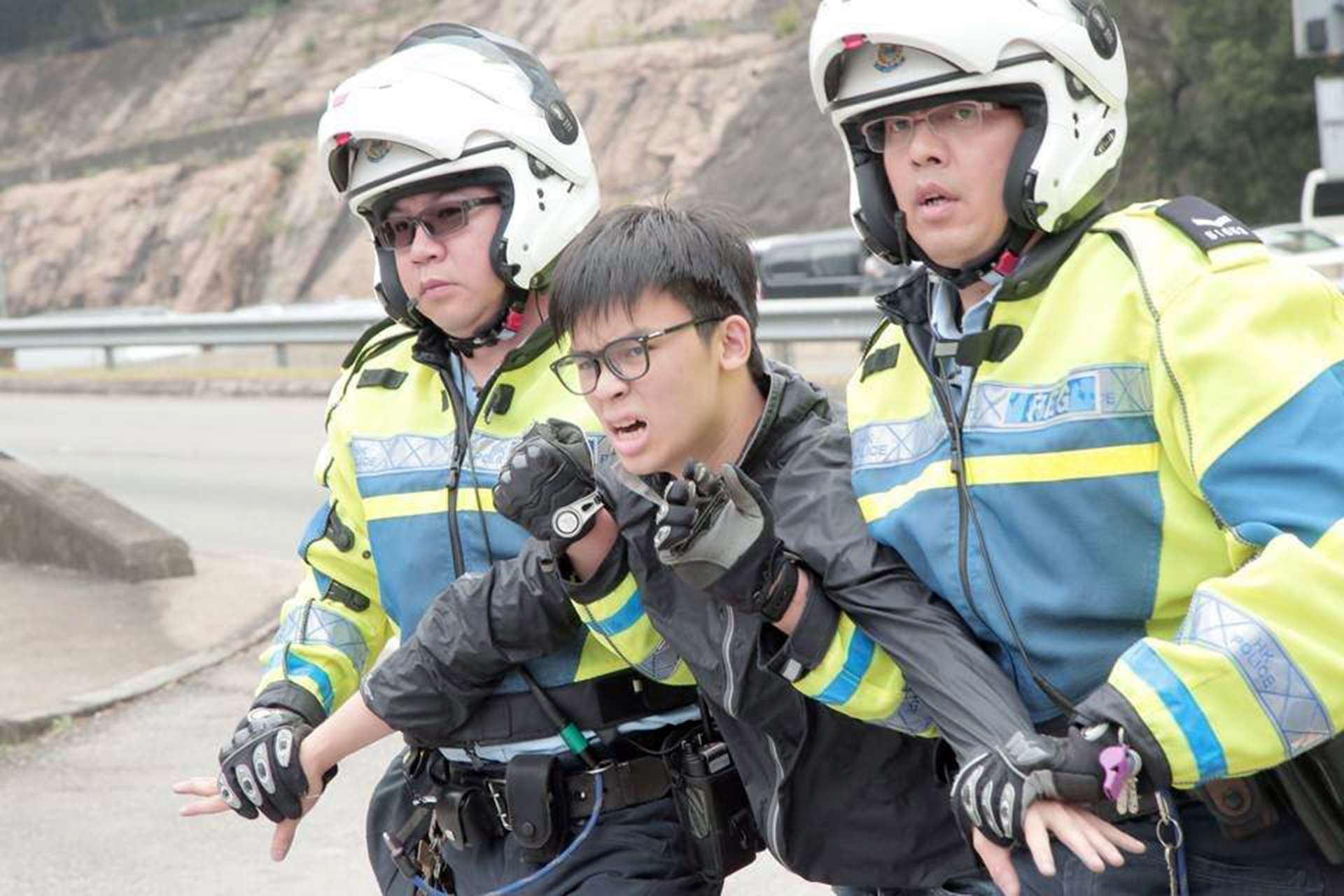Oscar Lai was taken away from the highway by police officers. Photo: SCMP Pictures
