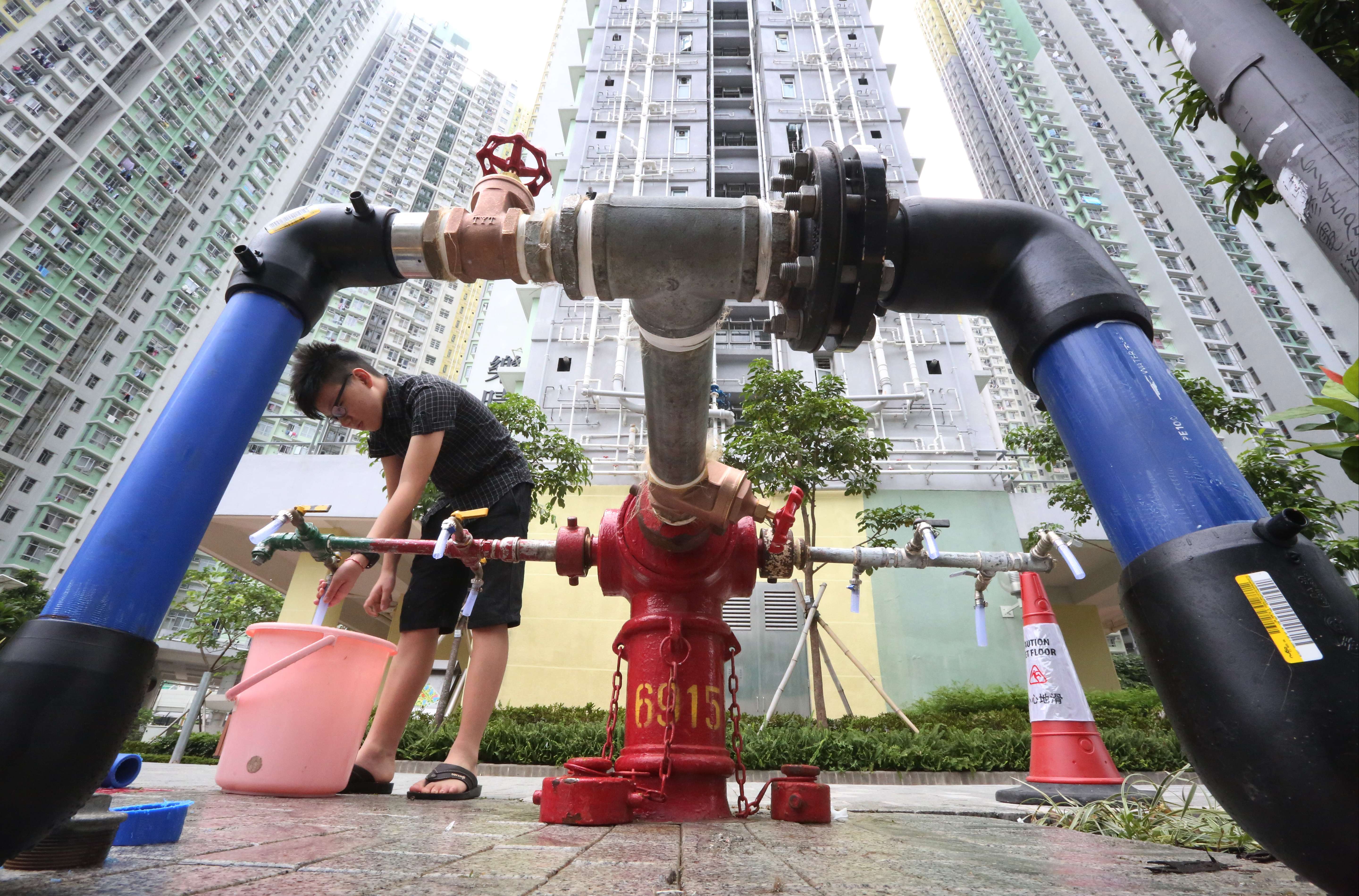 A resident of Kai Ching Estate in Kai Tak stocks up water from a fire hydrant after drinking water was found to be tainted with lead. Photo: Felix Wong