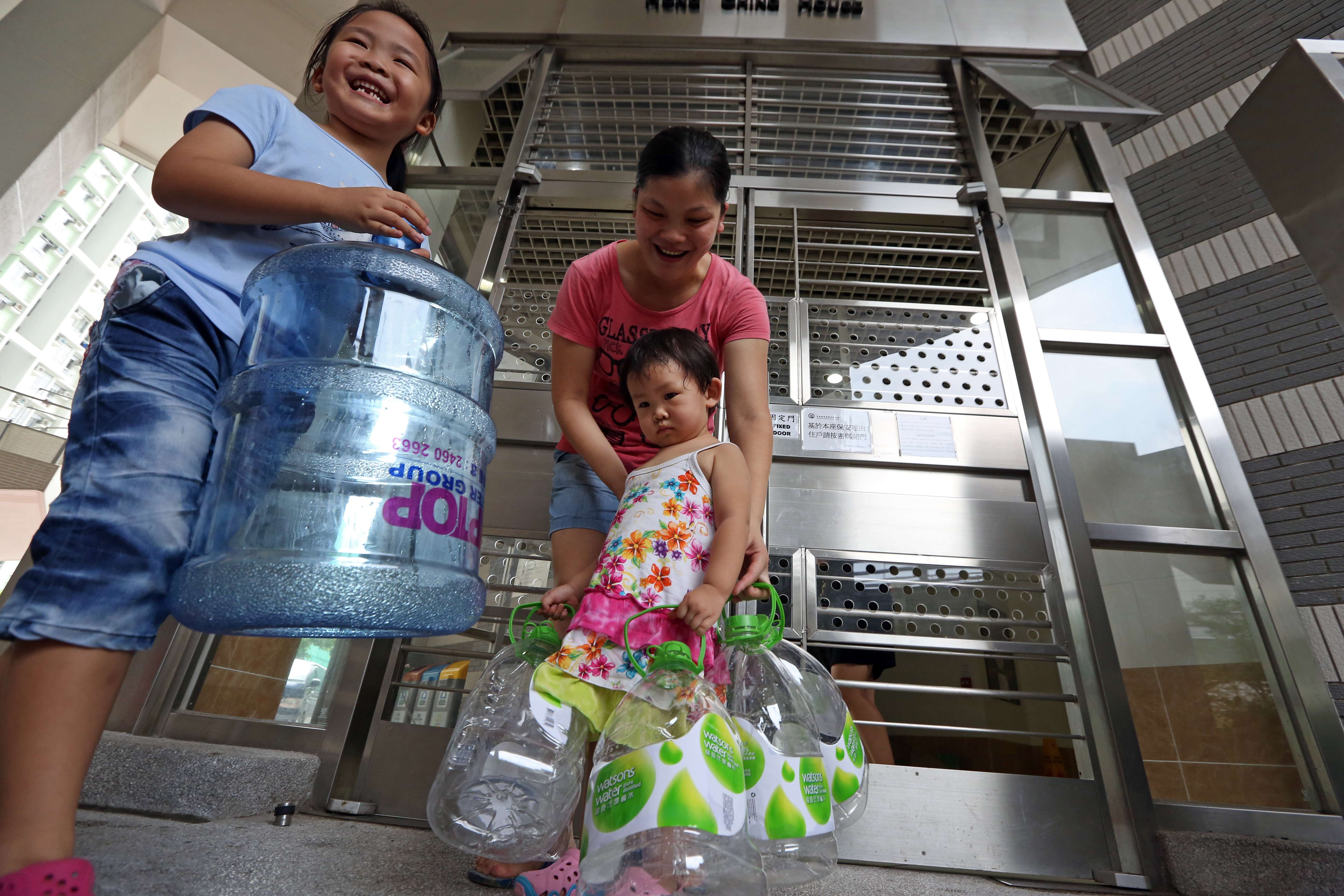 Residents at Kai Ching Estate in Kai Tak carry empty bottles for stocking water at temporary taps after last year’s scare. Photo: Nora Tam
