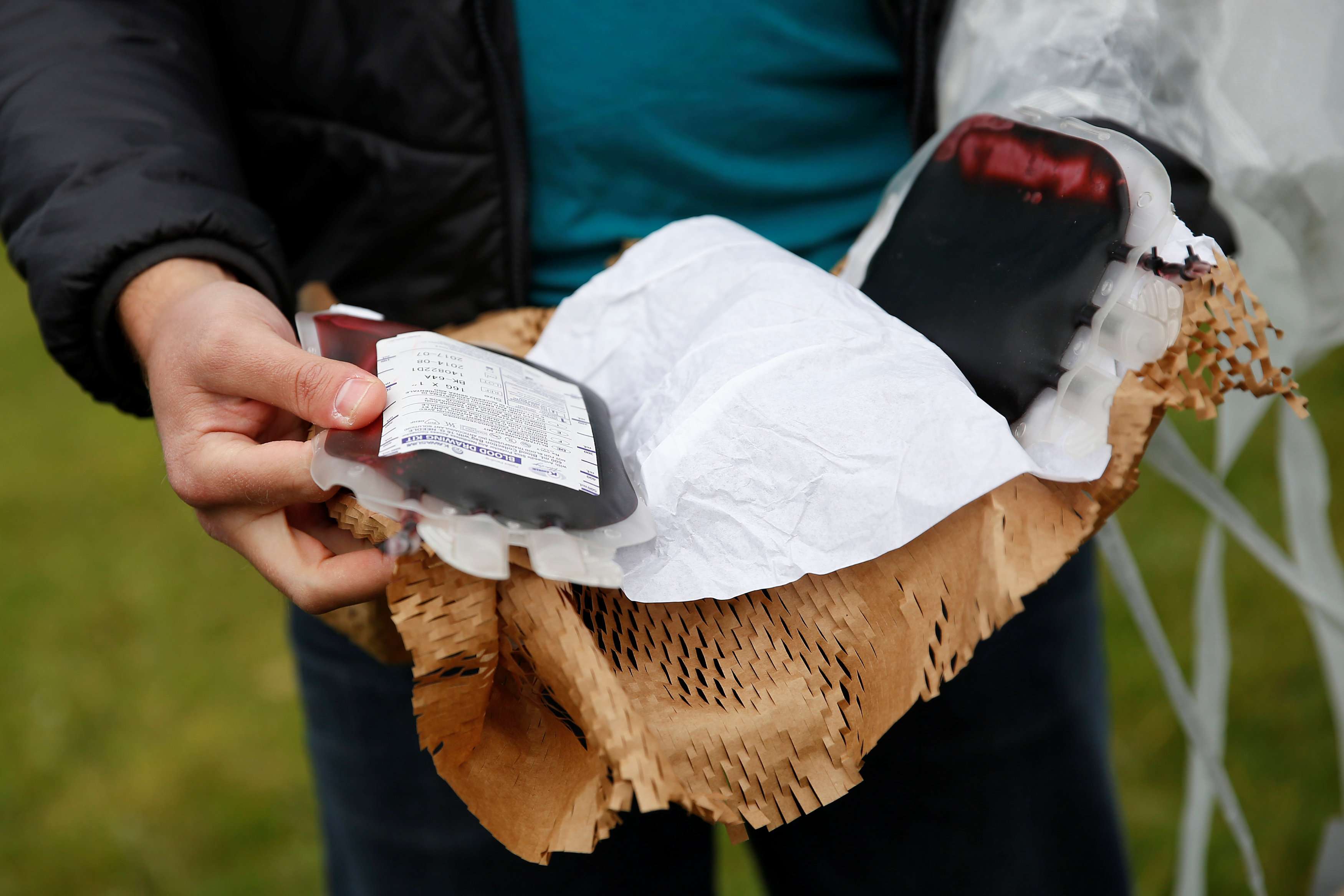 A Zipline employee displays a package of fake blood airdropped by one of its drones during a flight demonstration in the San Francisco Bay Area, California. This summer, the company will start delivering blood to hospitals and health centres in Rwanda. Photo: Reuters