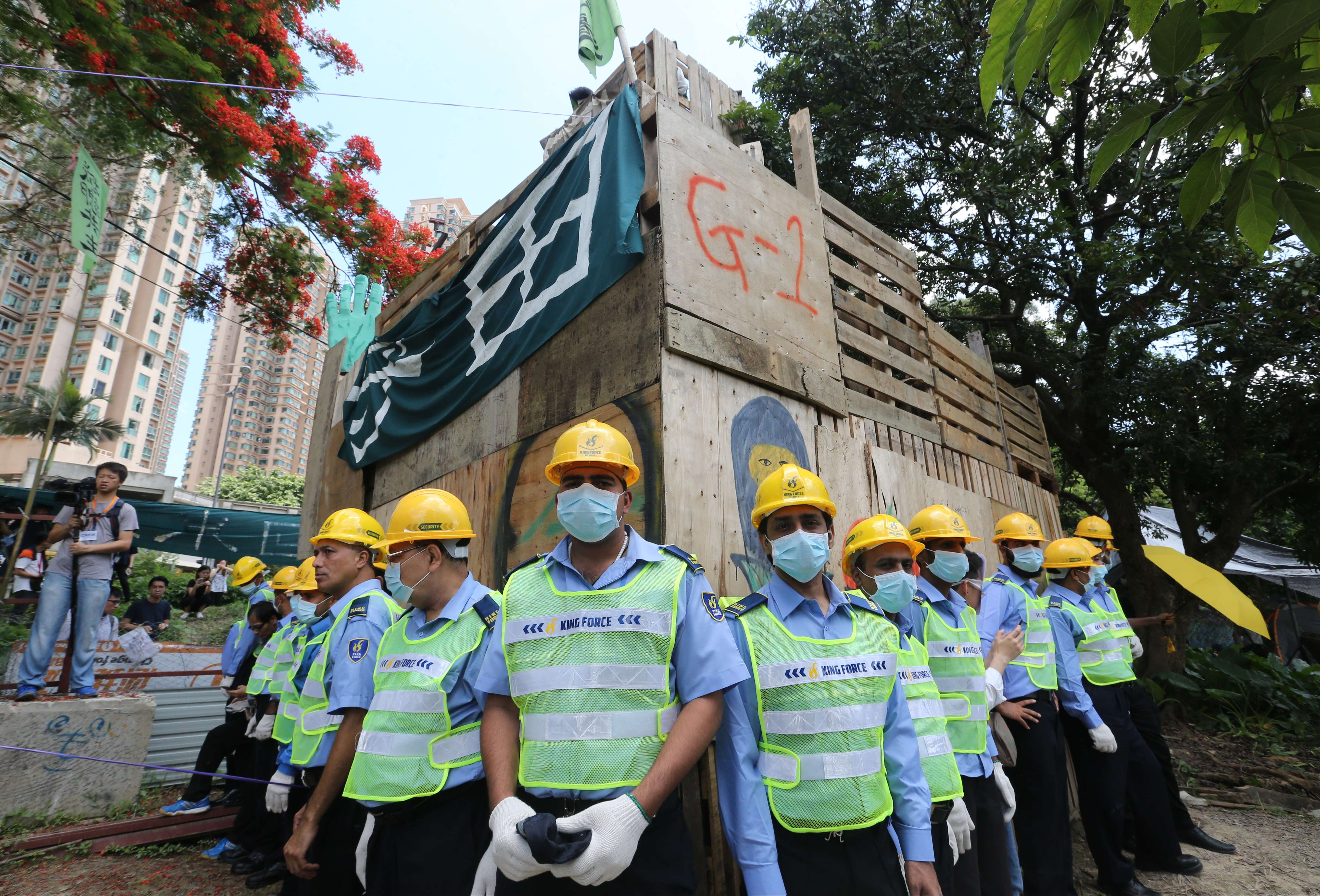 Security guards surround a wooden structure ascended by opponents of a development plan in the New Territories. Photo: Felix Wong