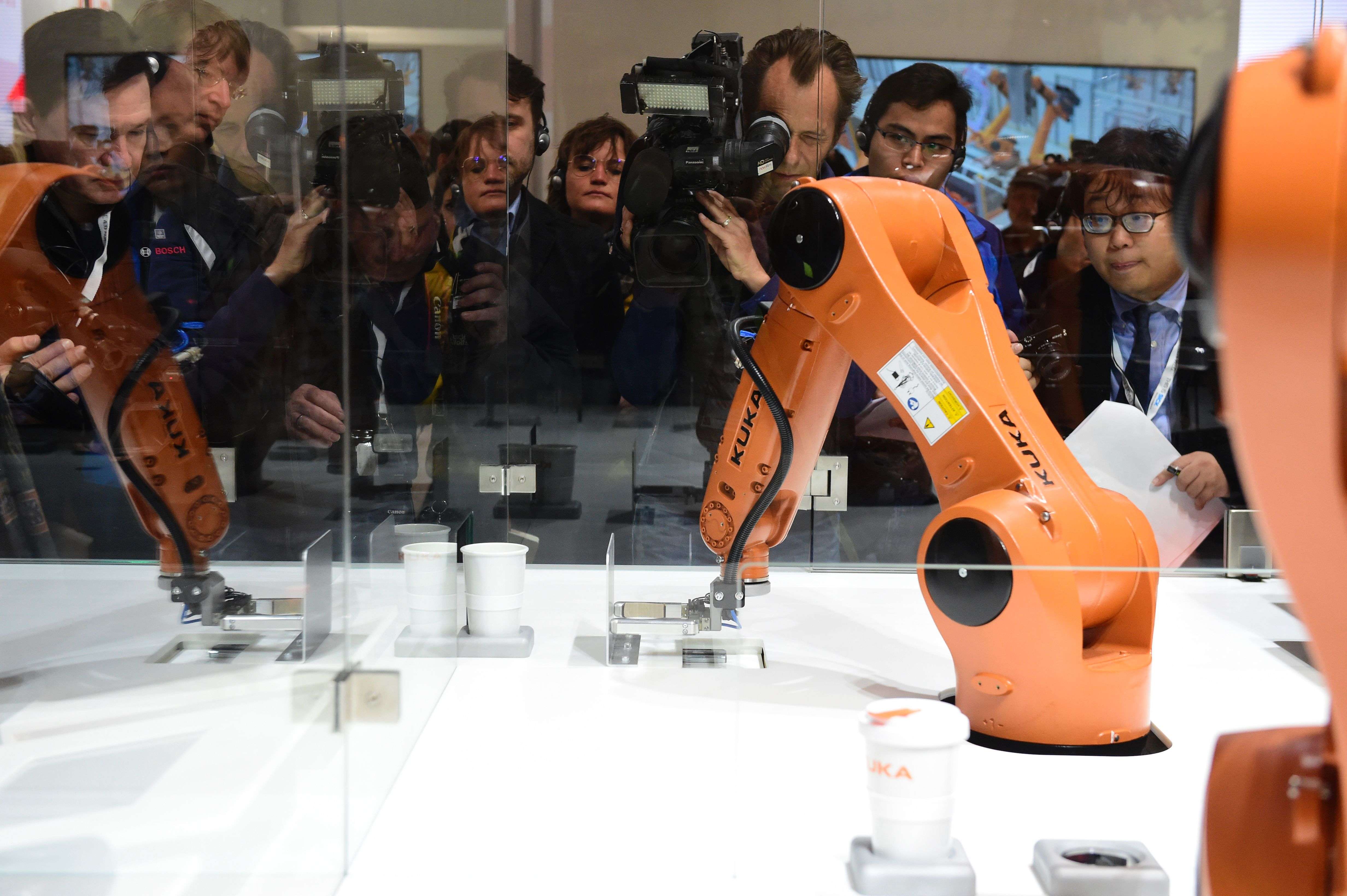 A robot prepares a cup of coffee at the booth of robotics manufacturer Kuka, on the eve of the opening of the Hanover Fair earlier this year. Photo: AFP