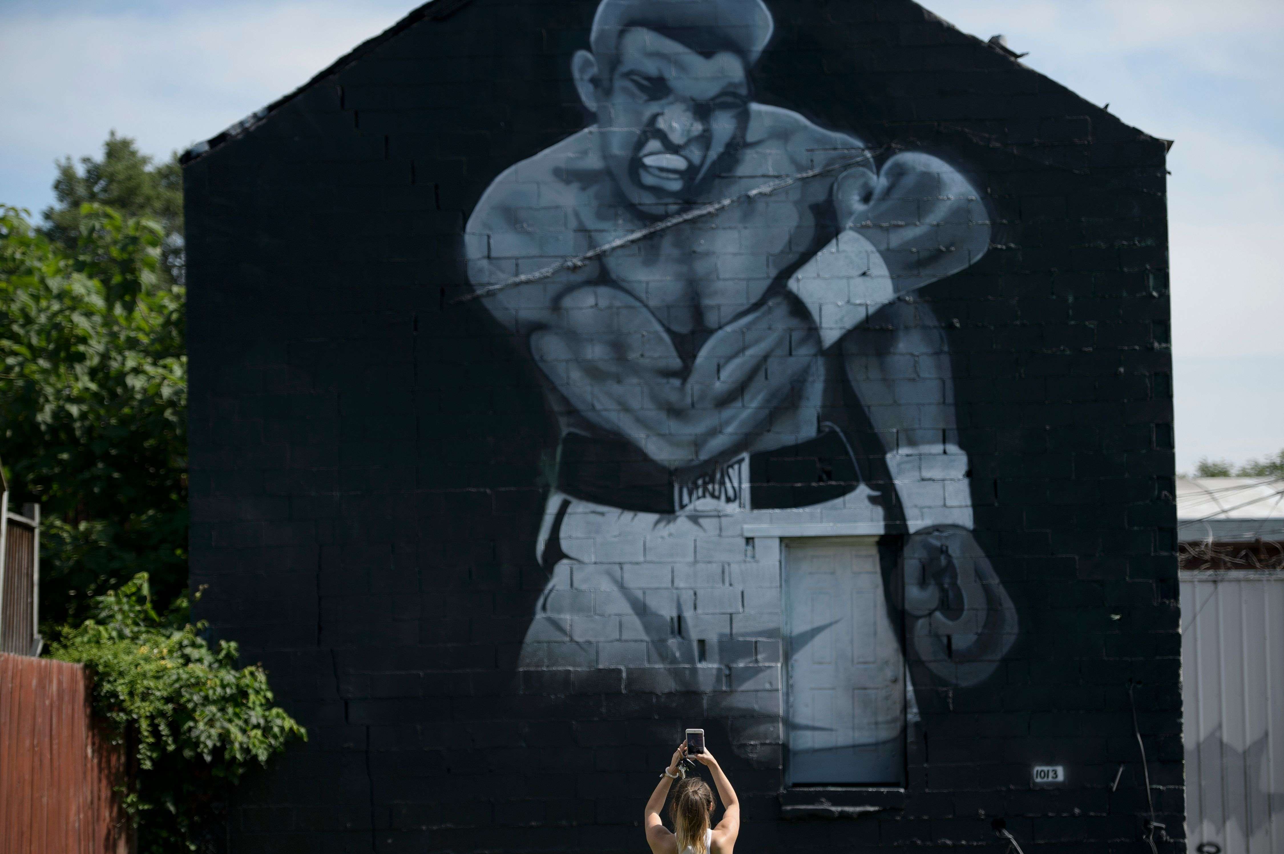 ‘Ali, Ali’ chant stabs air of summer day as casket rolls by