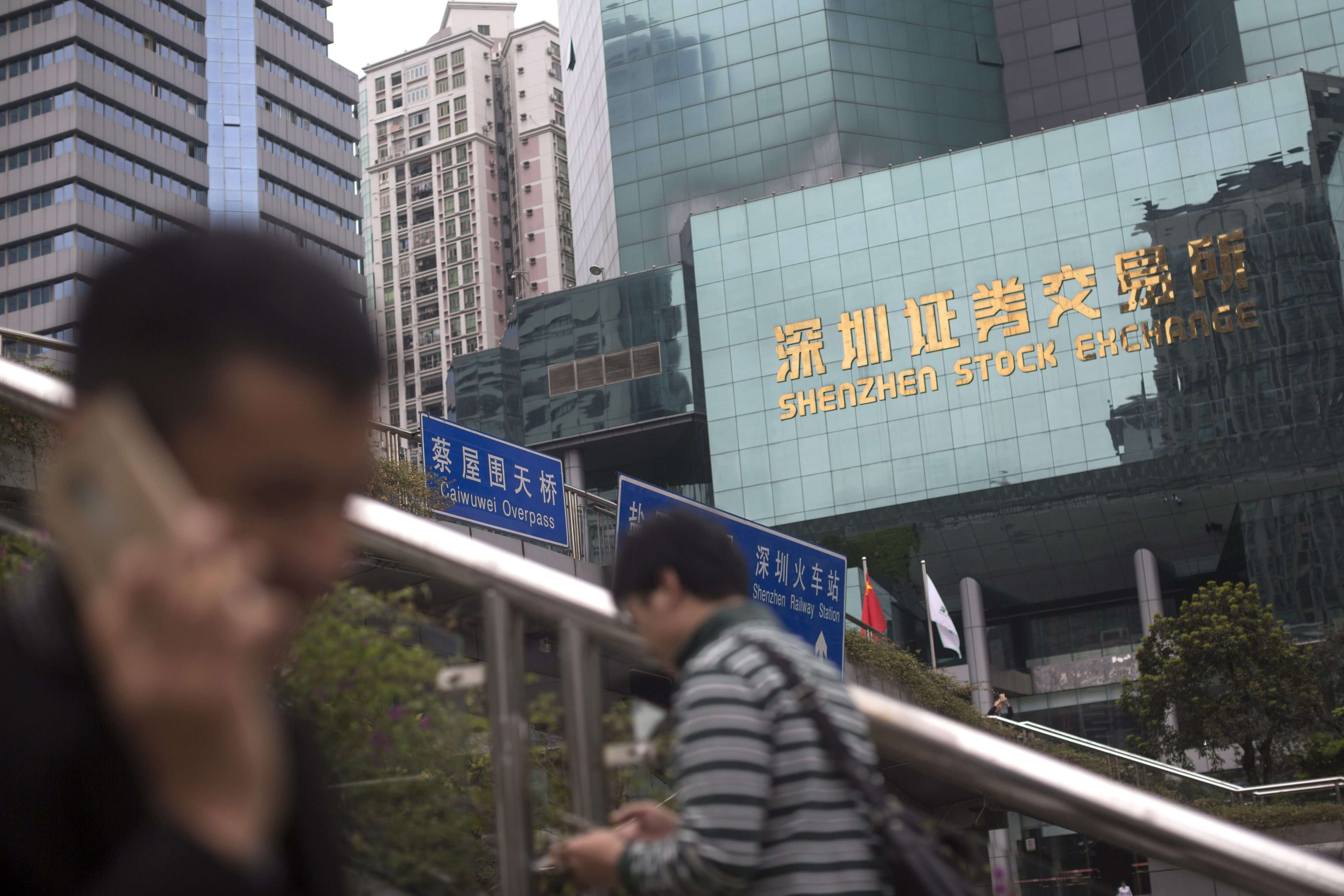 Shenzhen-Hong Kong Stock Connect may allow investors to trade on both bourses under a quota system. Photo: EPA epa05202350 People walk past the Shenzhen stock exchange in Shenzhen, Guangdong Province, China, 09 March 2016. According to the outline of the 13th five-year plan, China’s average annual rate of growth will slow from 7.8 per cent in the past five years to around 6.5 per cent, and per capita disposable income will also fall, from 7.7 per cent to around 6.5 per cent. EPA/FREDDY CHAN