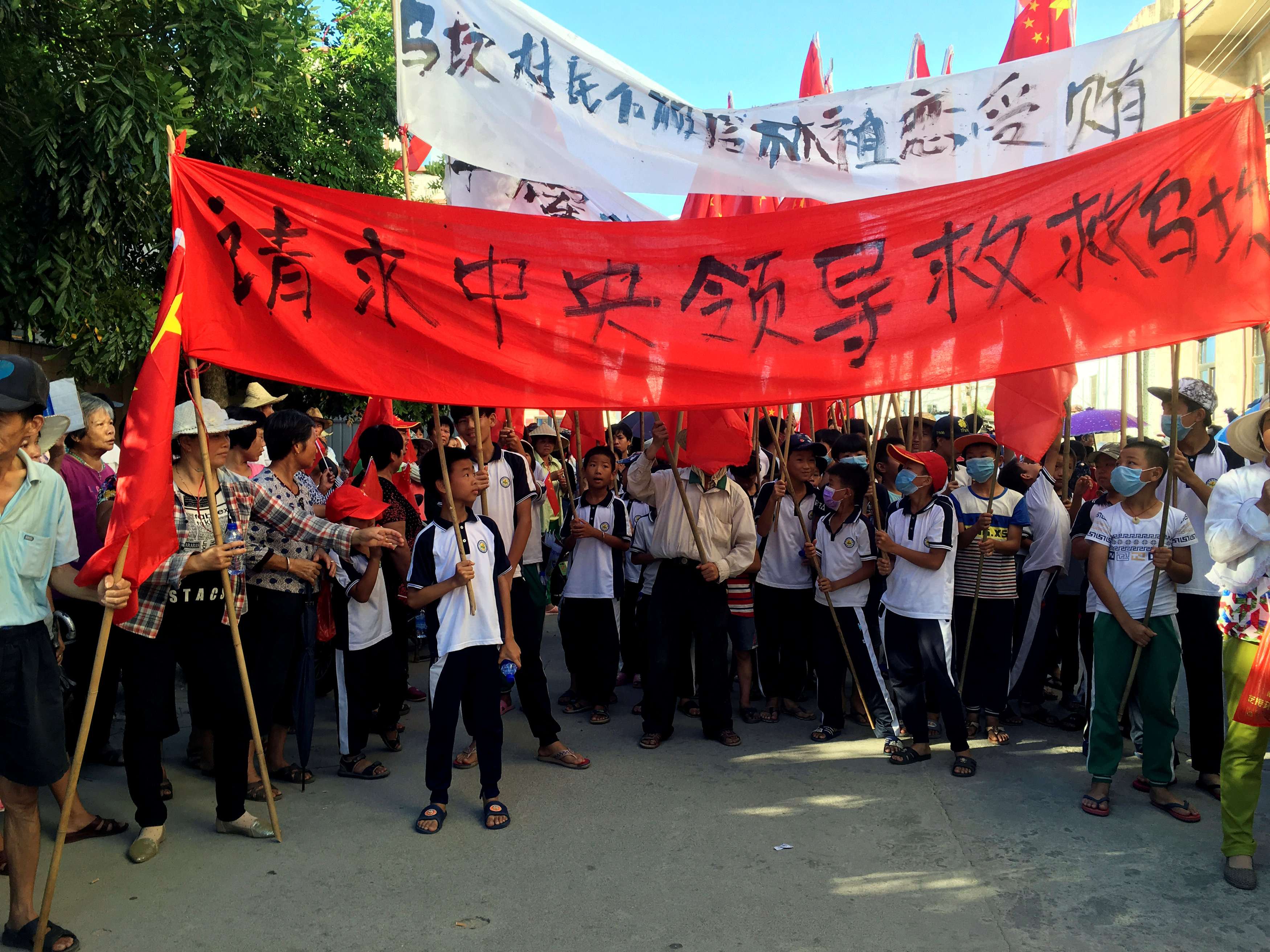 Villagers carry banners which read “Plead the central government to help Wukan” (in red) and “Wukan villagers don't believe Lin Zuluan took bribes” during a protest in Wukan, Guangdong province on Wednesday. Photo: Reuters