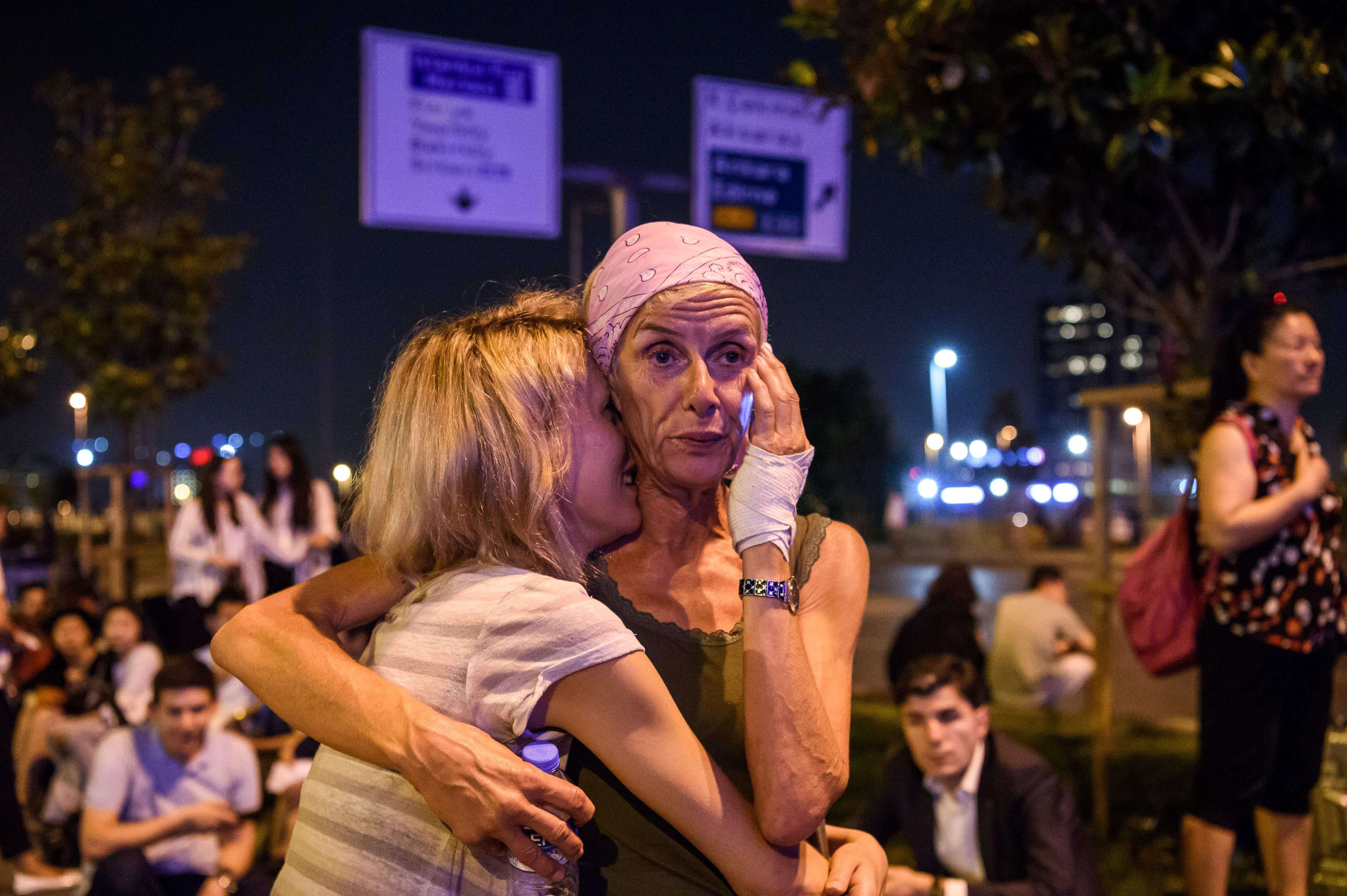 Passengers embrace outside Ataturk airport`s main entrance in Istanbul, after two explosions followed by gunfire hit Turkey's largest airport. Photo: AFP