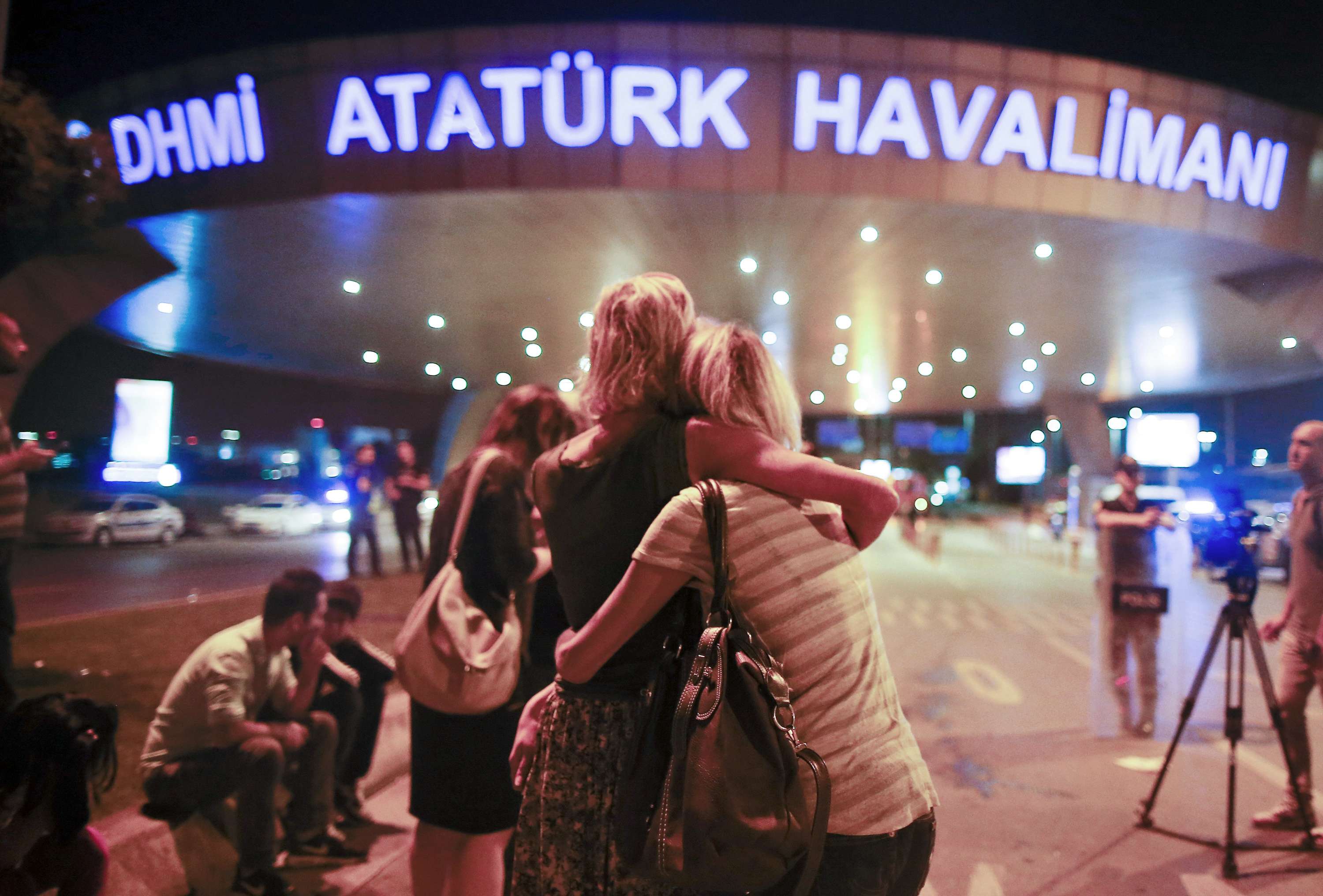 Passengers embrace each other at the entrance to Istanbul's Ataturk airport following their evacuation after a blast. Photo: AP