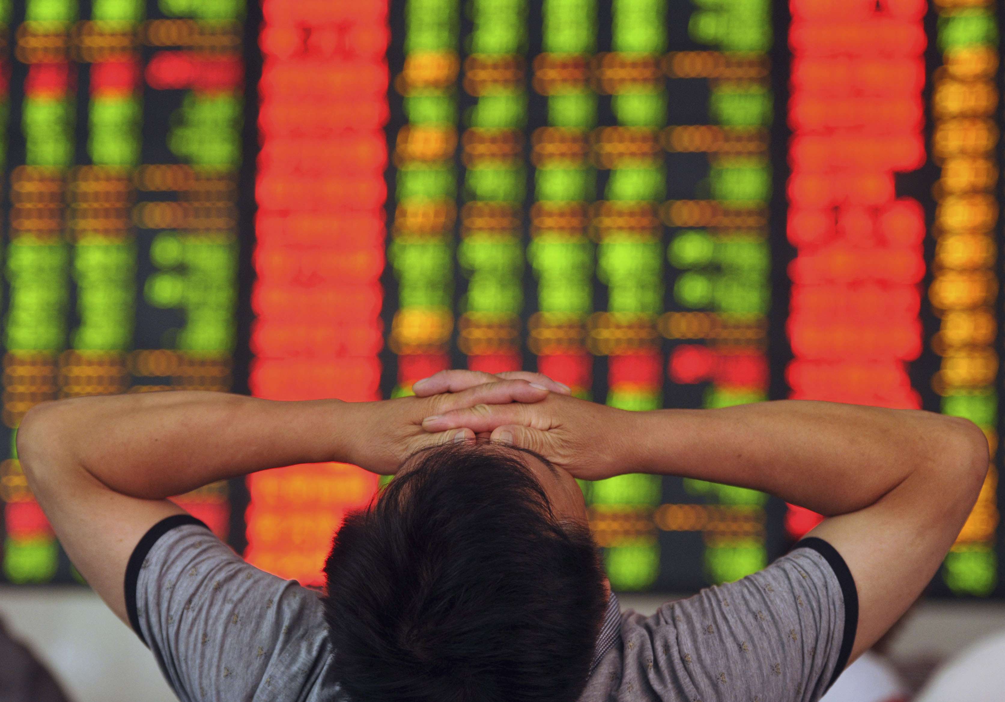A stock investor covers his eyes at a brokerage house in Fuyang in Anhui province on July 8, 2015. Photo: AP