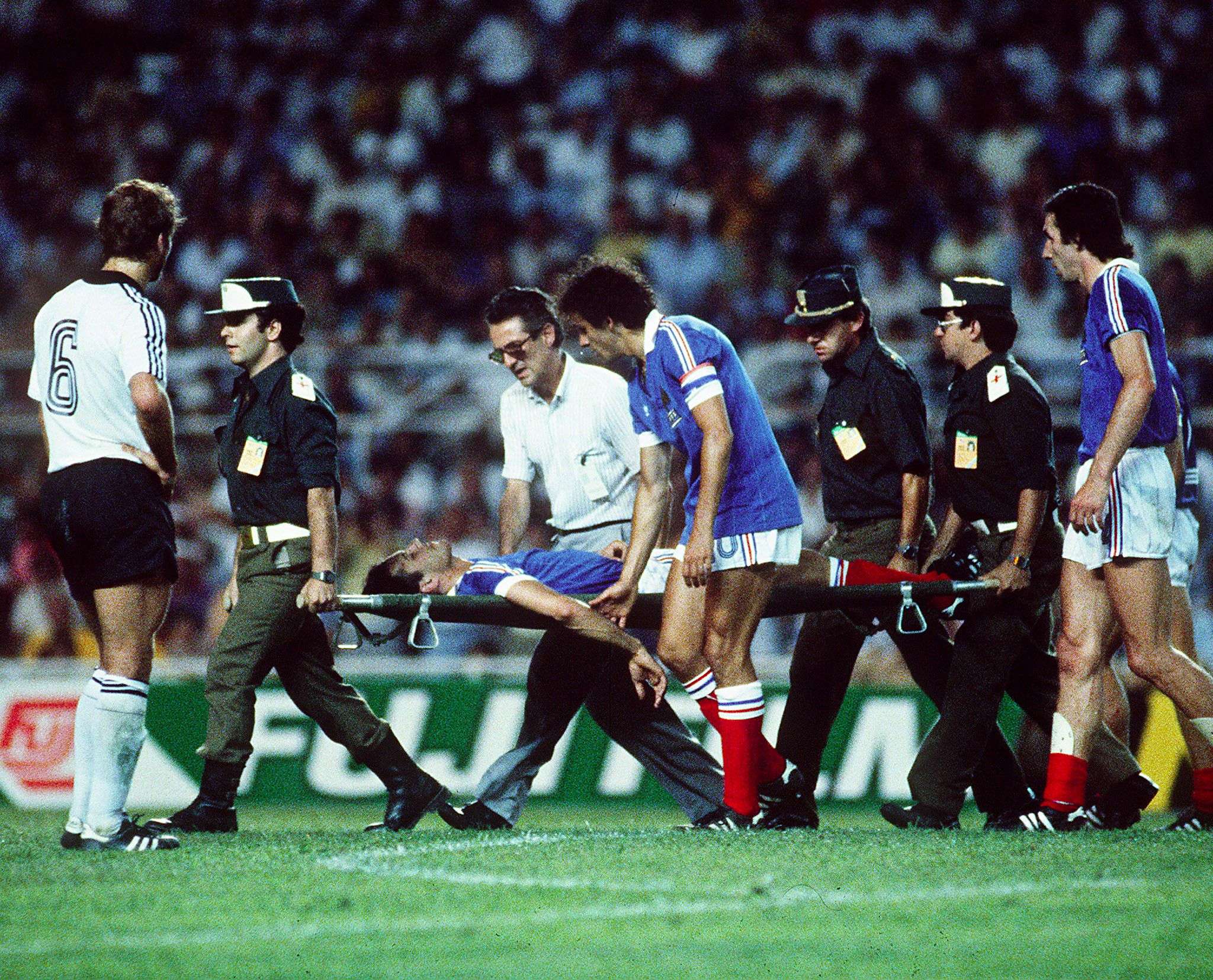 Patrick Battiston evacuated on a stretcher eyed by forward Michel Platini after colliding with German goalkeeper Harald Schumacher during the World Cup semi-final. Photo: AFP