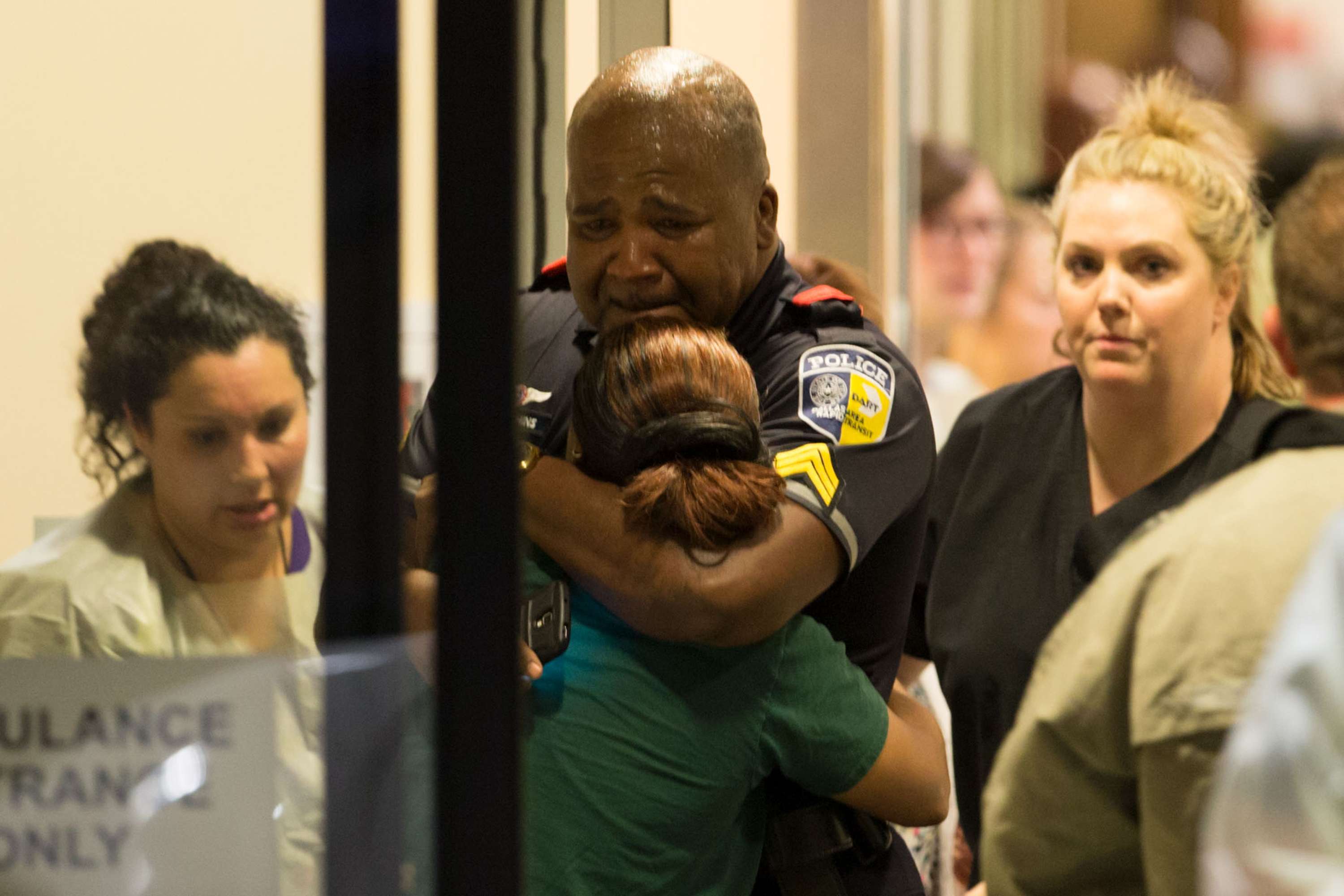 A DART (Dallas Area Rapid Transit) police officer receives comfort at Baylor University Hospital emergency room entrance on Thursday, July 7, 2016, in Dallas. Photo: TNS