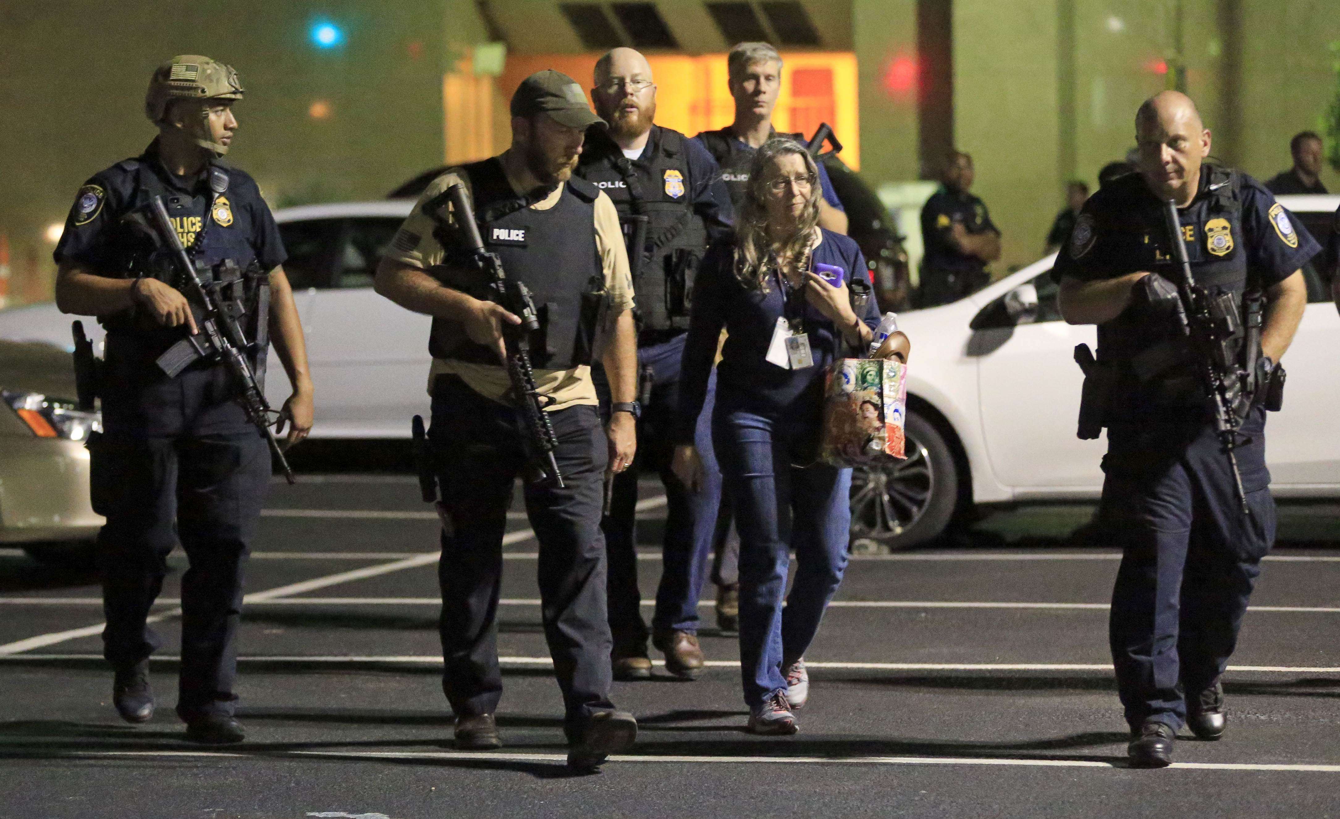 Dallas police officers escort a woman near the scene where eleven Dallas police officers were shot and five have now died on July 7, 2016 in Dallas, Texas. Photo: AFP