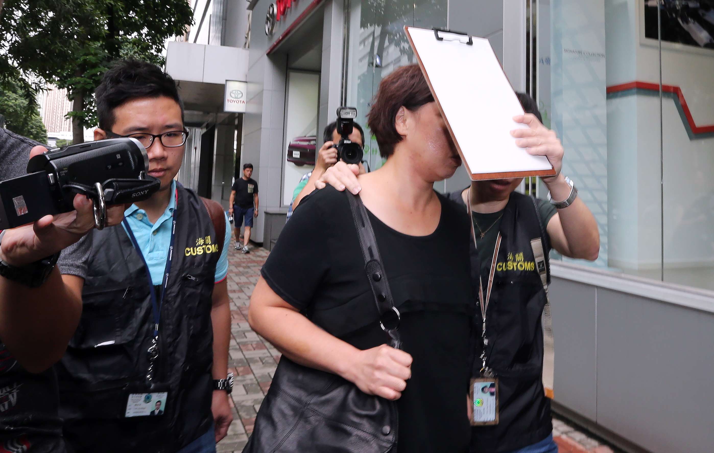 An unidentified senior official of the California Fitness was taken away by officers of the Hong Kong Customs and Excise Department from the Kowloon Bay Office for further investigation.Photo: Felix Wong