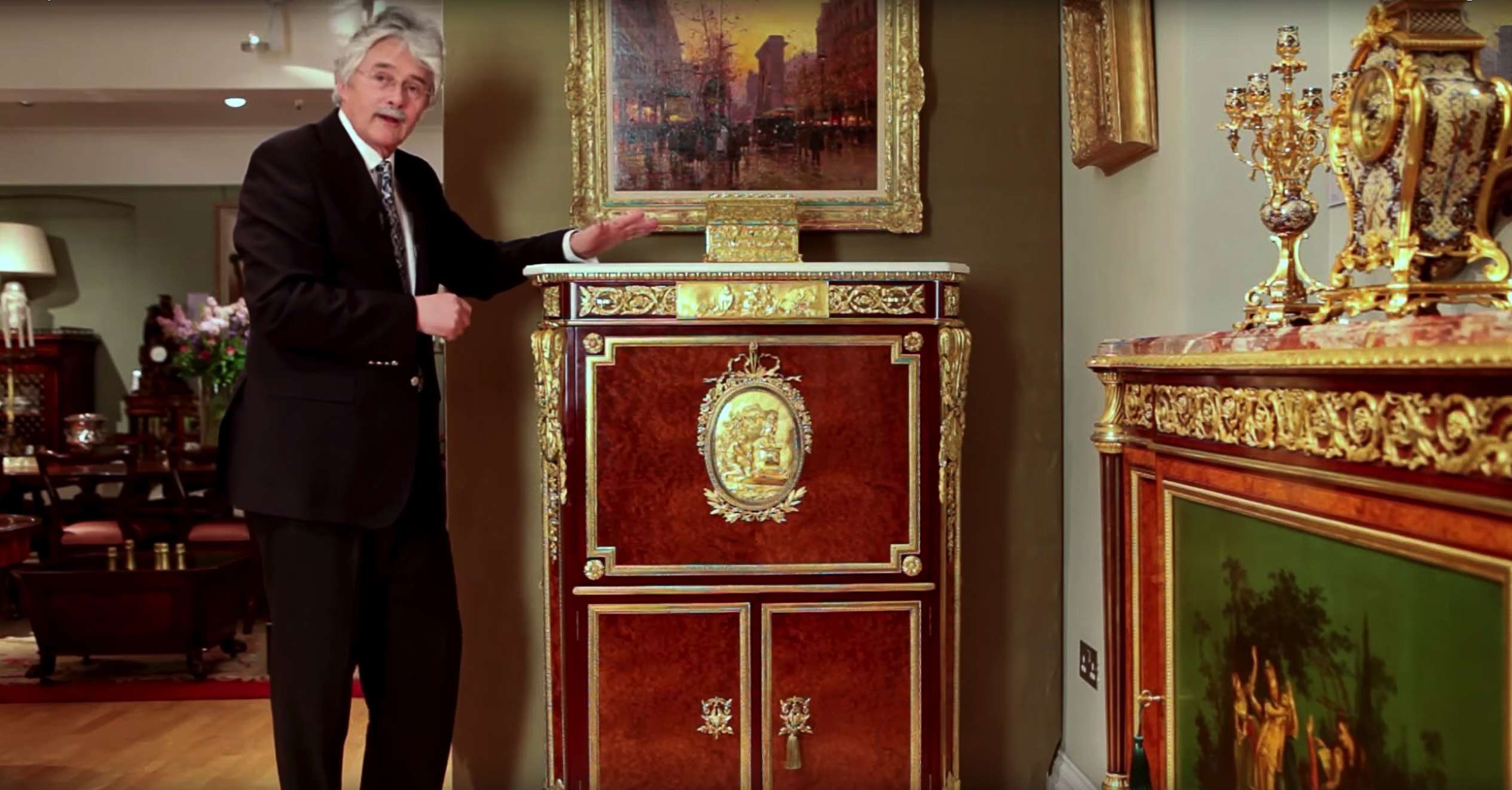 Furniture historian Christopher Payne poses next to a unique secretaire abattant, made as an exact copy of one in the Wallace Collection of art and antiques on display in London.